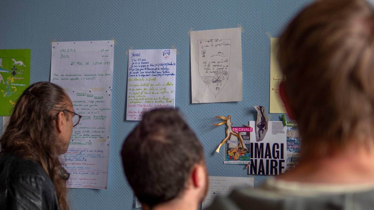 Participant·es qui consultent les blasons des personnes présentes lors d’un événement de rencontres pour un projet de hameau léger