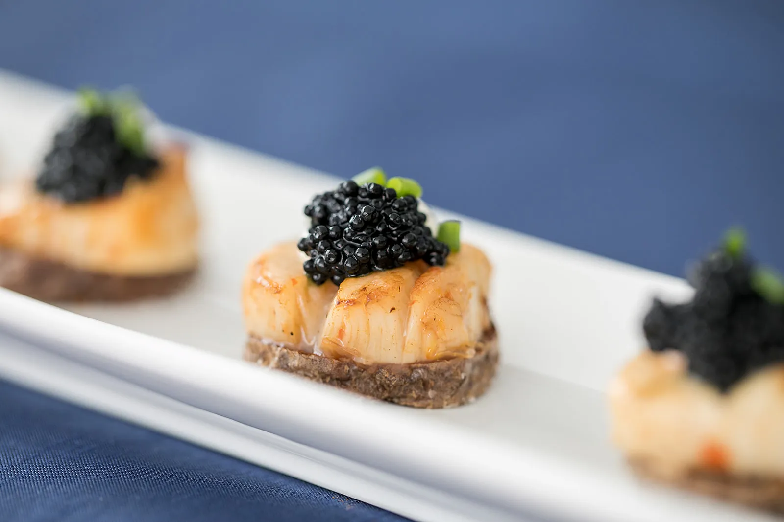 Canape of pan seared bass with caviar on top.