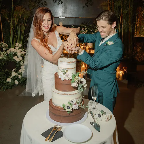 A couple cutting their wedding cake.