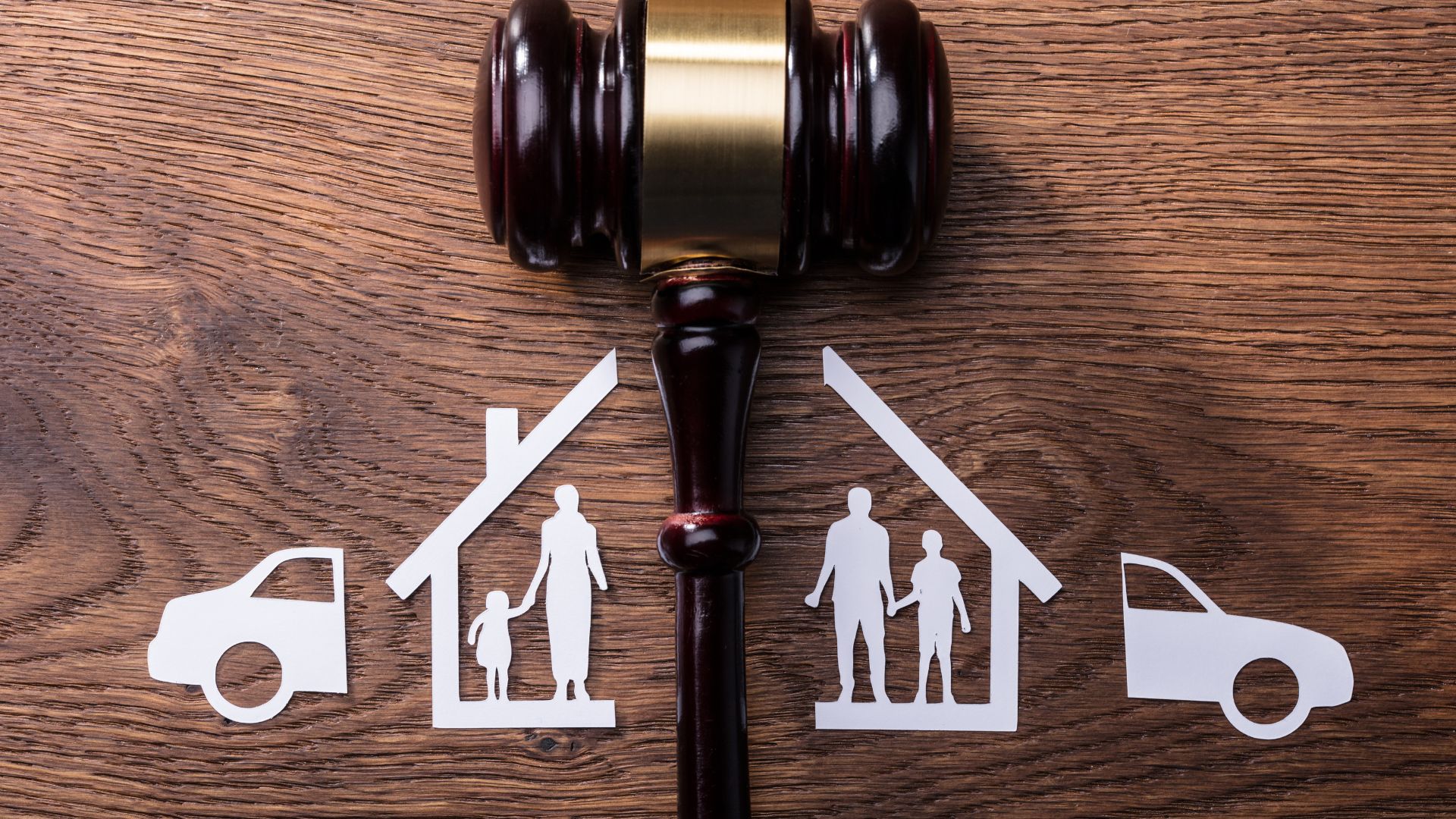 Richterhammer zwischen getrennter Familie als Symbol für Scheidung.