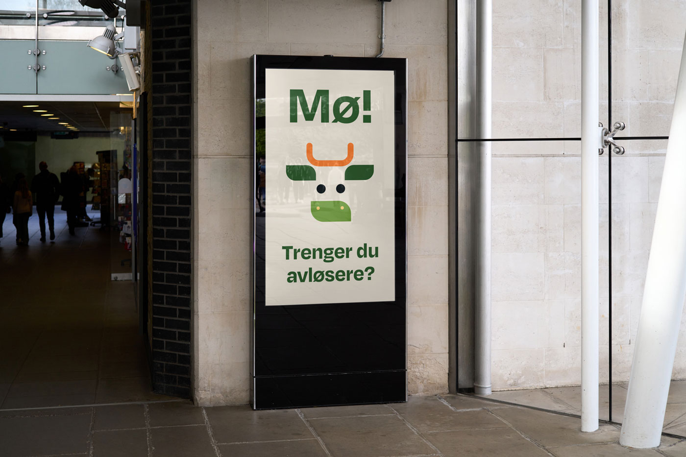Digitalt skilt i en gate med en illustrasjon av et okseskilt og teksten 'Mø! Trenger du avløsere?' i grønne bokstaver.