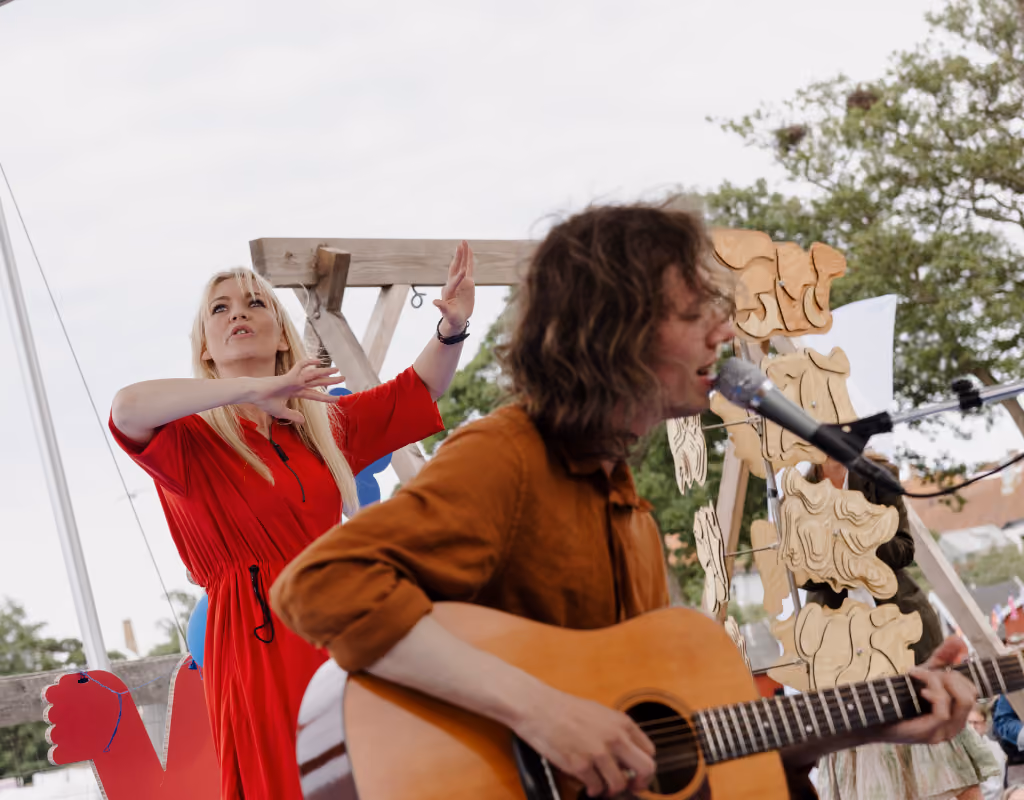 The universal design concert as seen from the audience with a performance interpreter in the back, singer in front