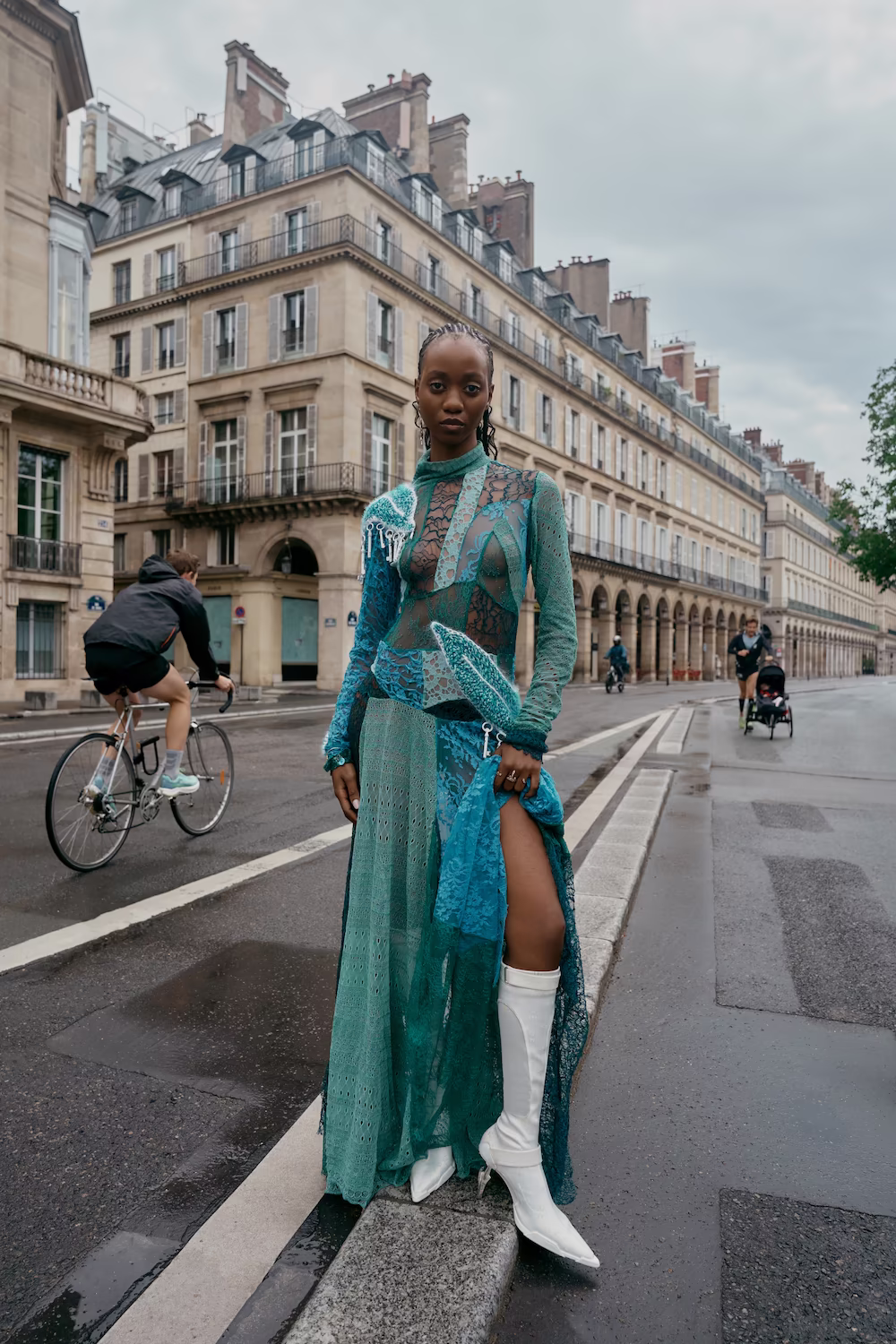 Model in a sheer teal lace gown and white boots on a Paris street — fashion editorial