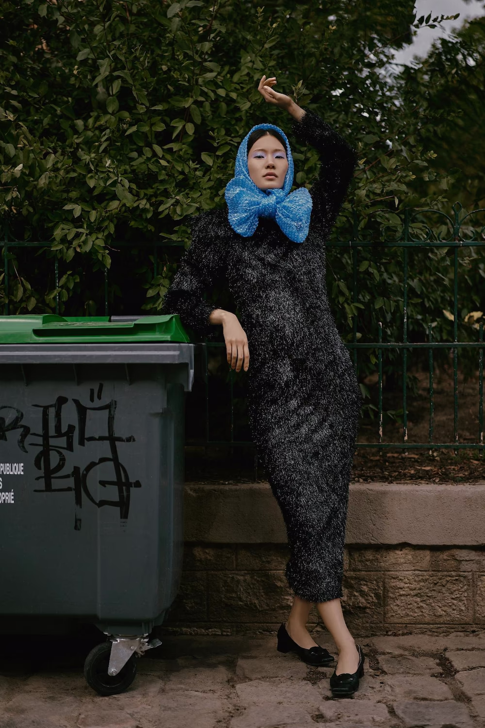 Model in a black sparkle dress and blue bow headscarf on a Paris street — fashion editorial
