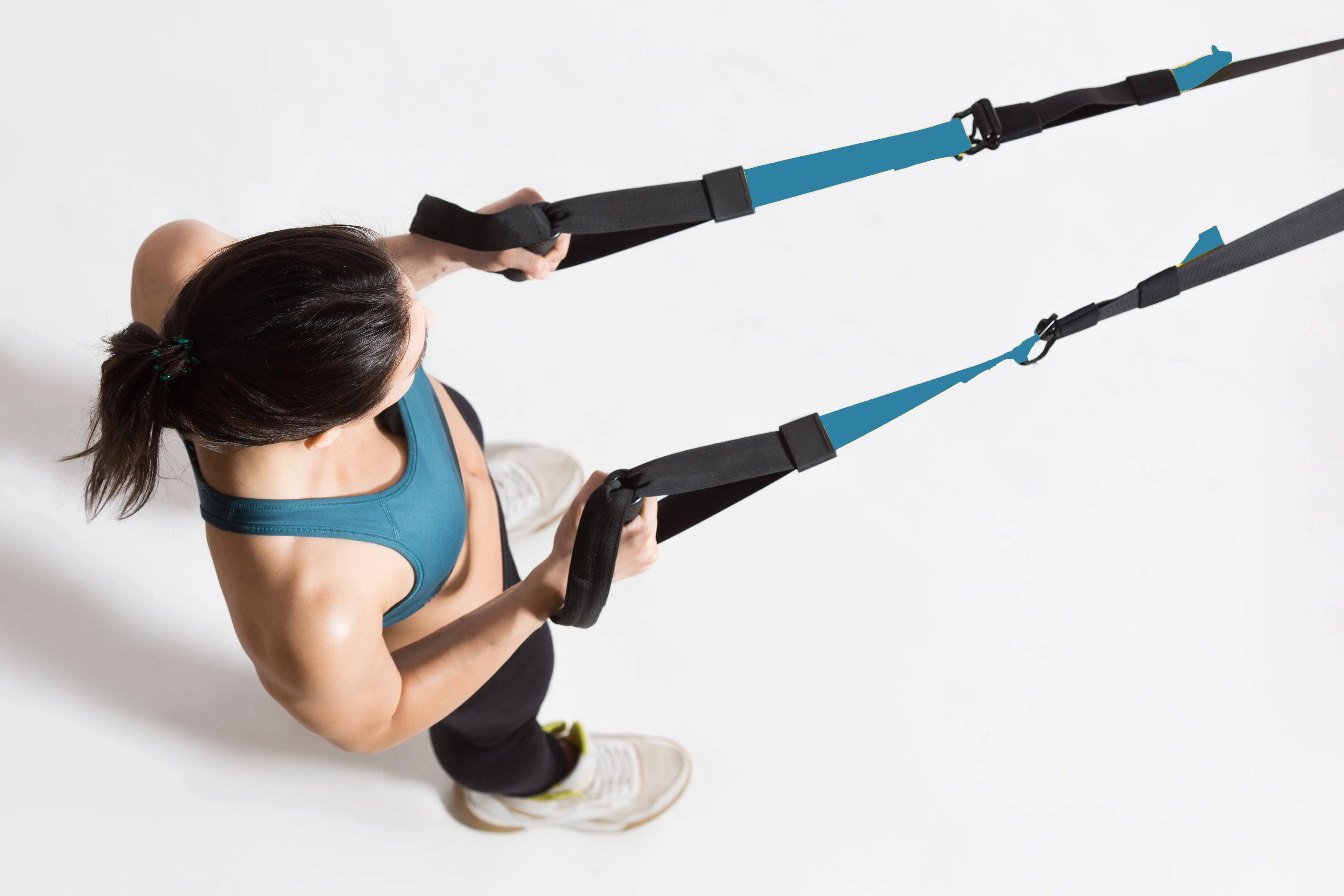 Frau trainiert mit Seilzügen an der Wandhalterung