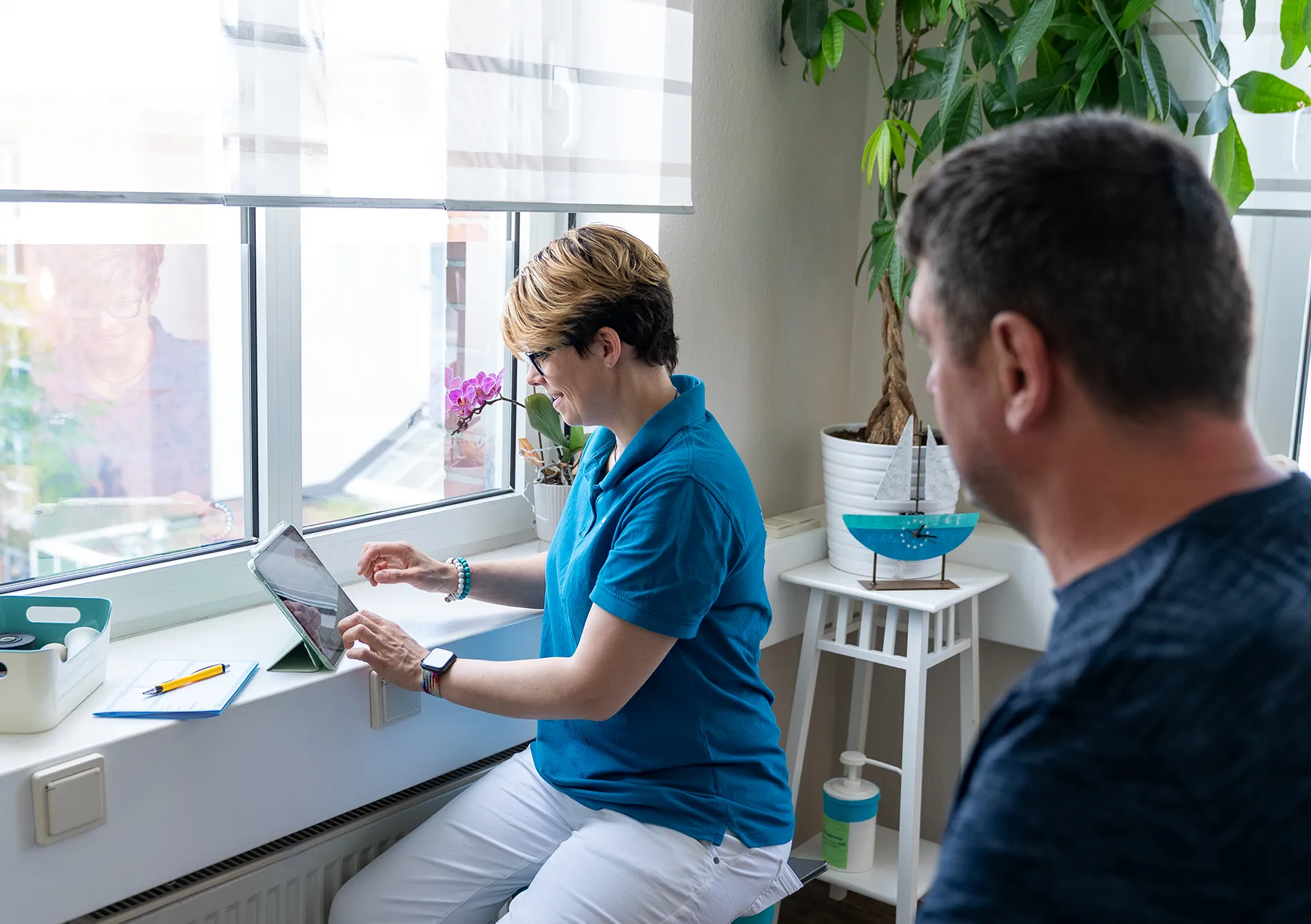Physiotherapeut arbeitet mit Patientin an Geräten.