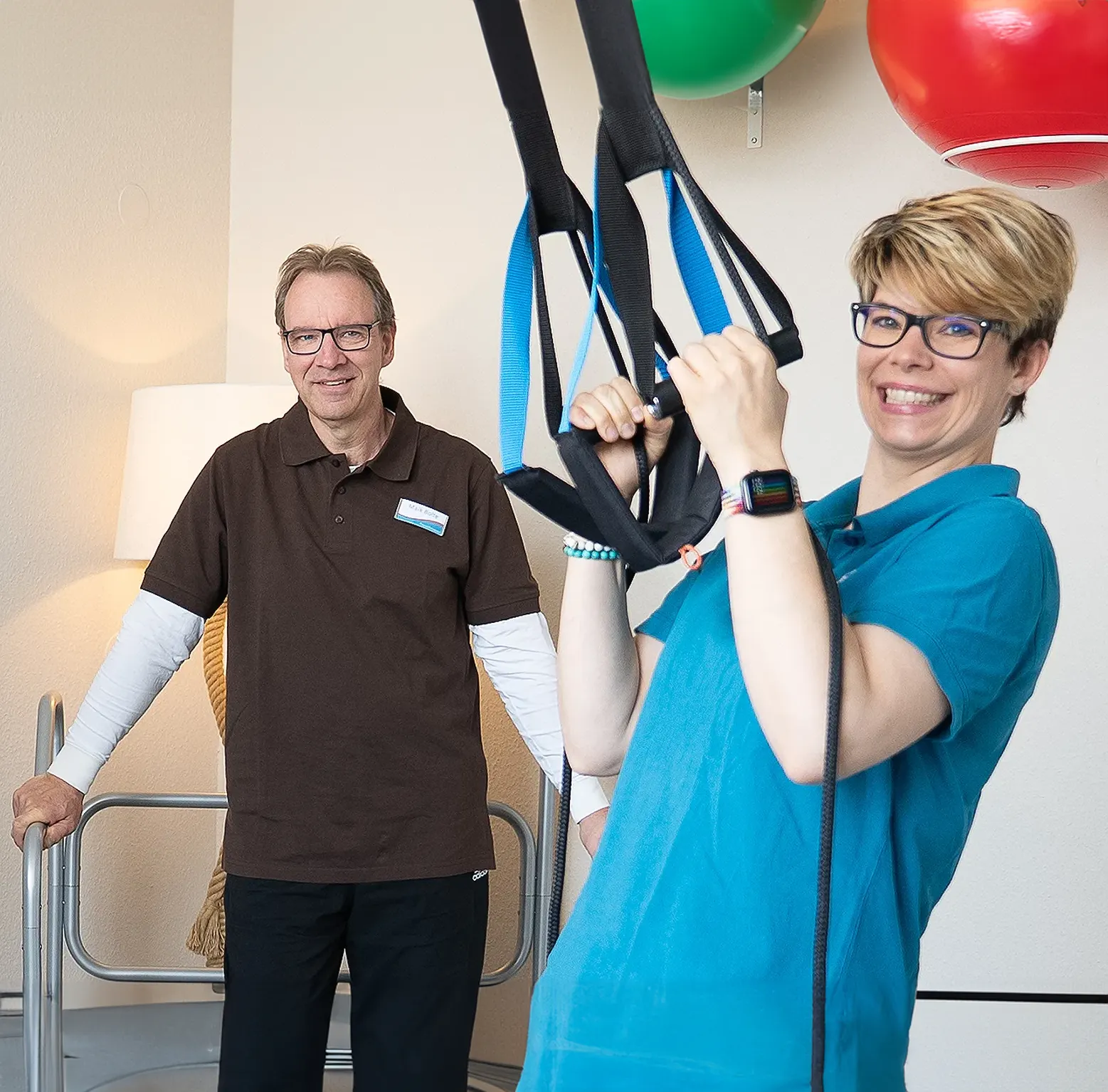 Zwei Therapeuten demonstrieren Übungen im Trainingsraum.