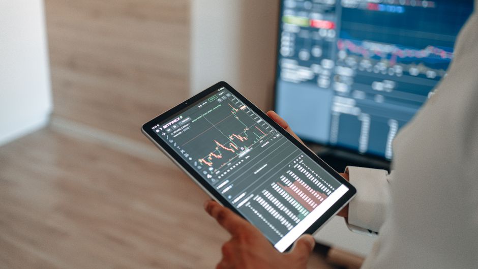 A person uses a tablet to monitor stock market trends and real-time trading graphs.. Photo by AlphaTradeZone on Pexels