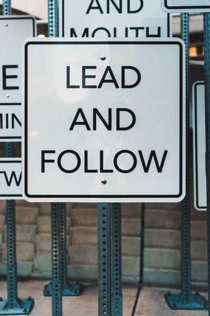 Photo of urban signage displaying 'Lead and Follow', emphasizing guidance and navigation.. Photo by Tim Mossholder on Pexels