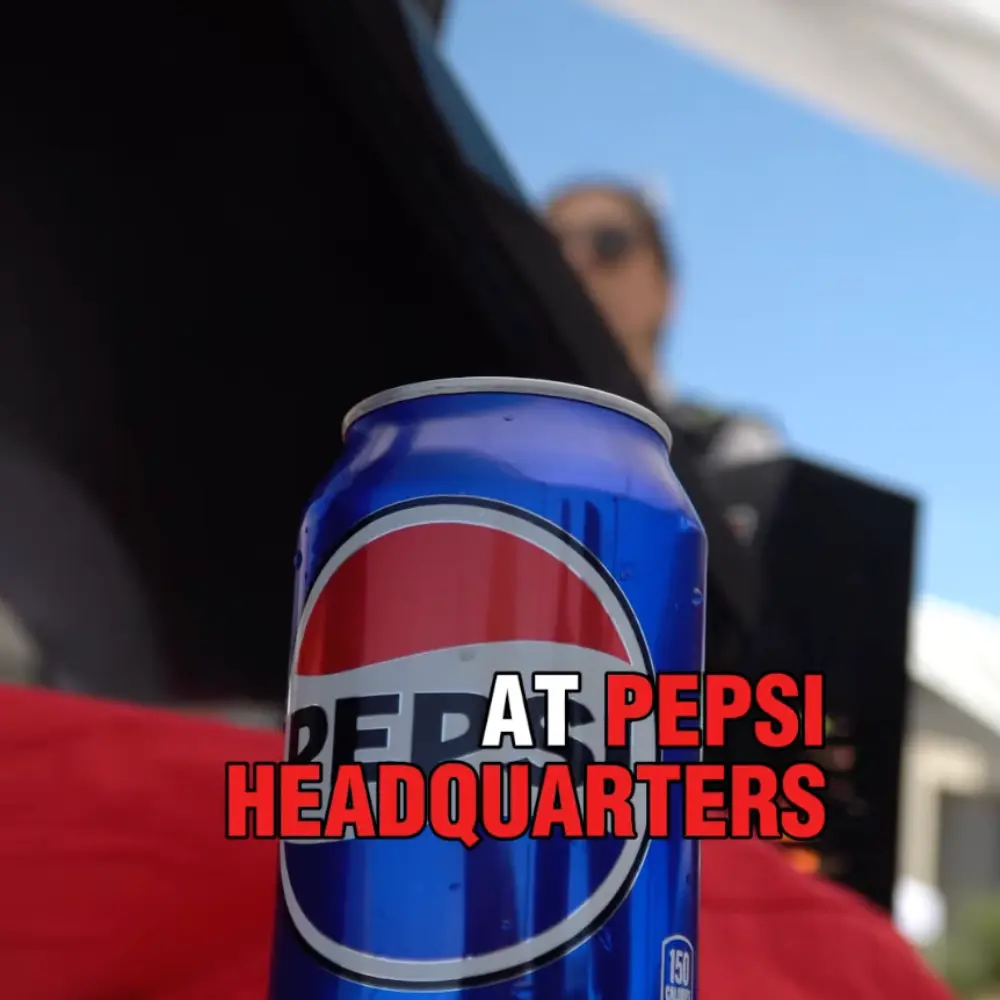 Pepsi can with logo in foreground at Pepsi headquarters, promoting custom screen printing services.