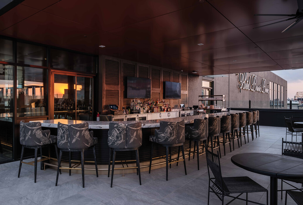 A bar with a lot of chairs around it.
