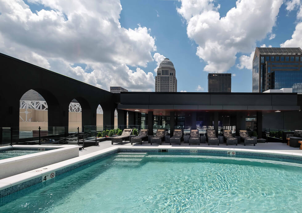 A large swimming pool in front of a city skyline.