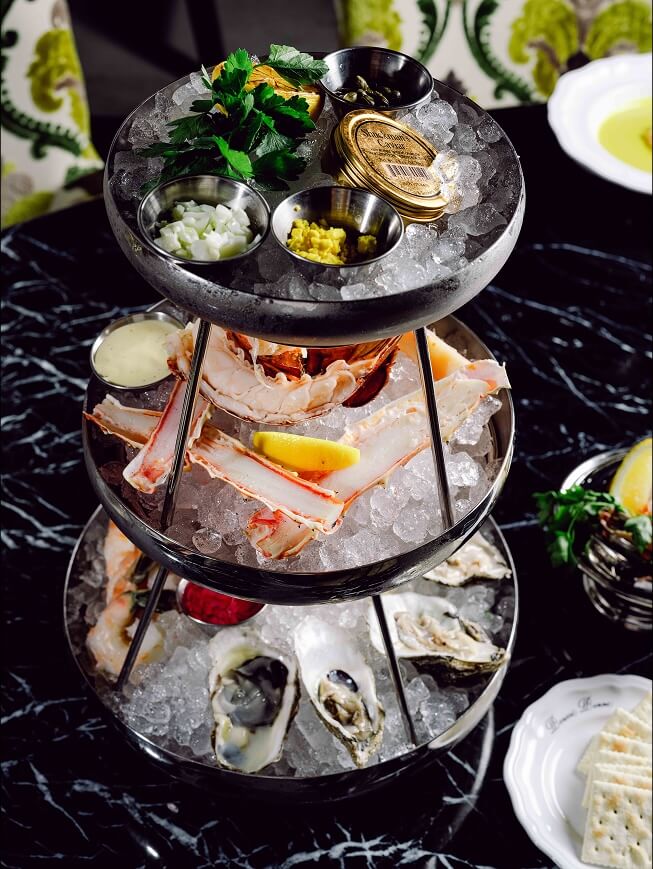 A three tiered tray of food on a table.