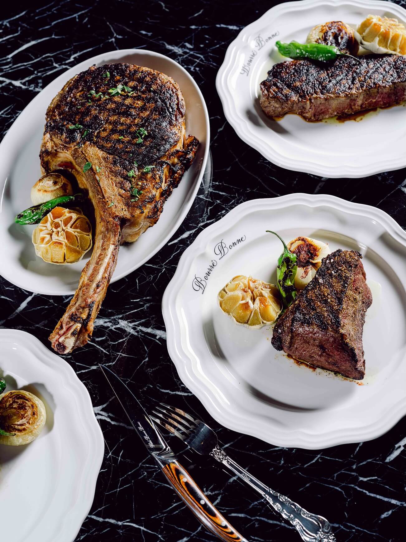 A table topped with three plates of food.