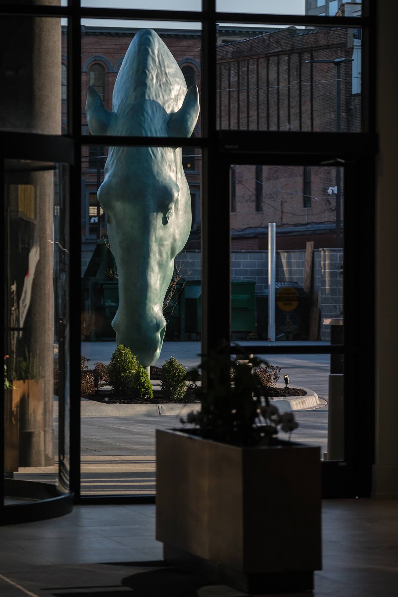 A statue of a polar bear is seen through a window.