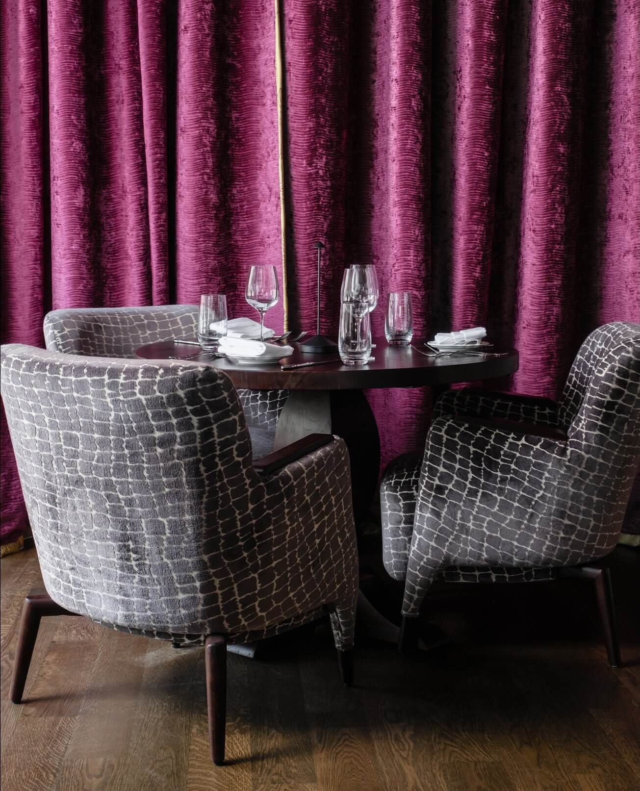 A table with two chairs and a wine glass.