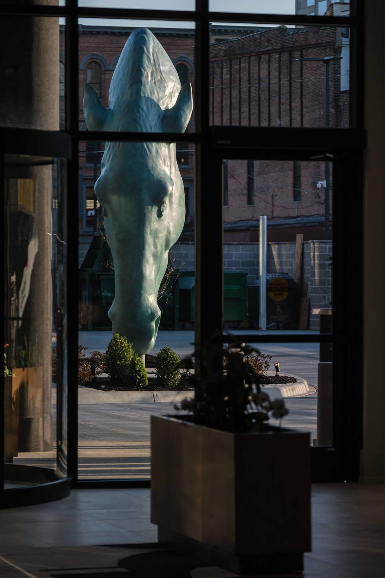 A statue of a polar bear is seen through a window.