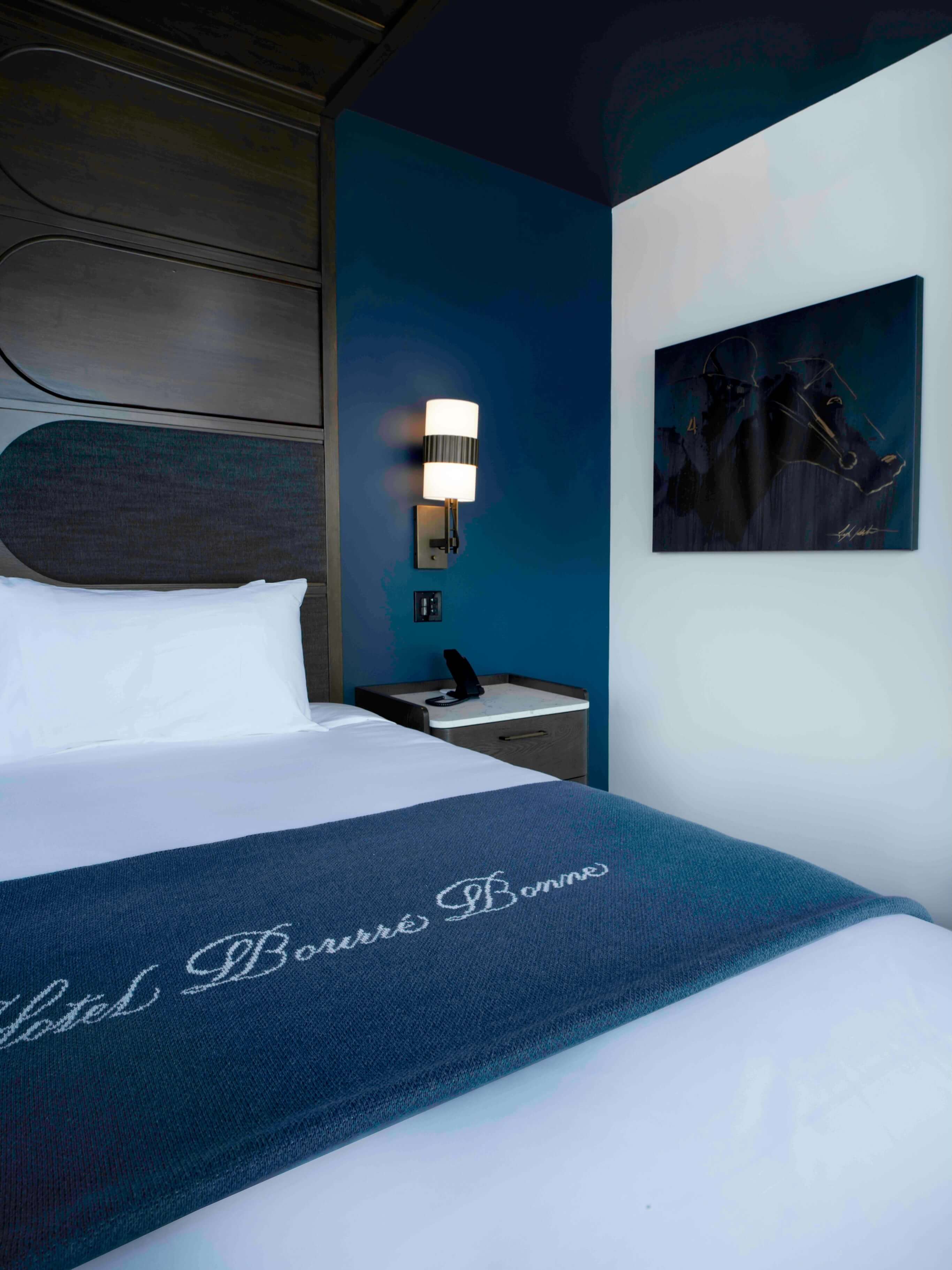 A hotel room with a bed and a picture on the wall.