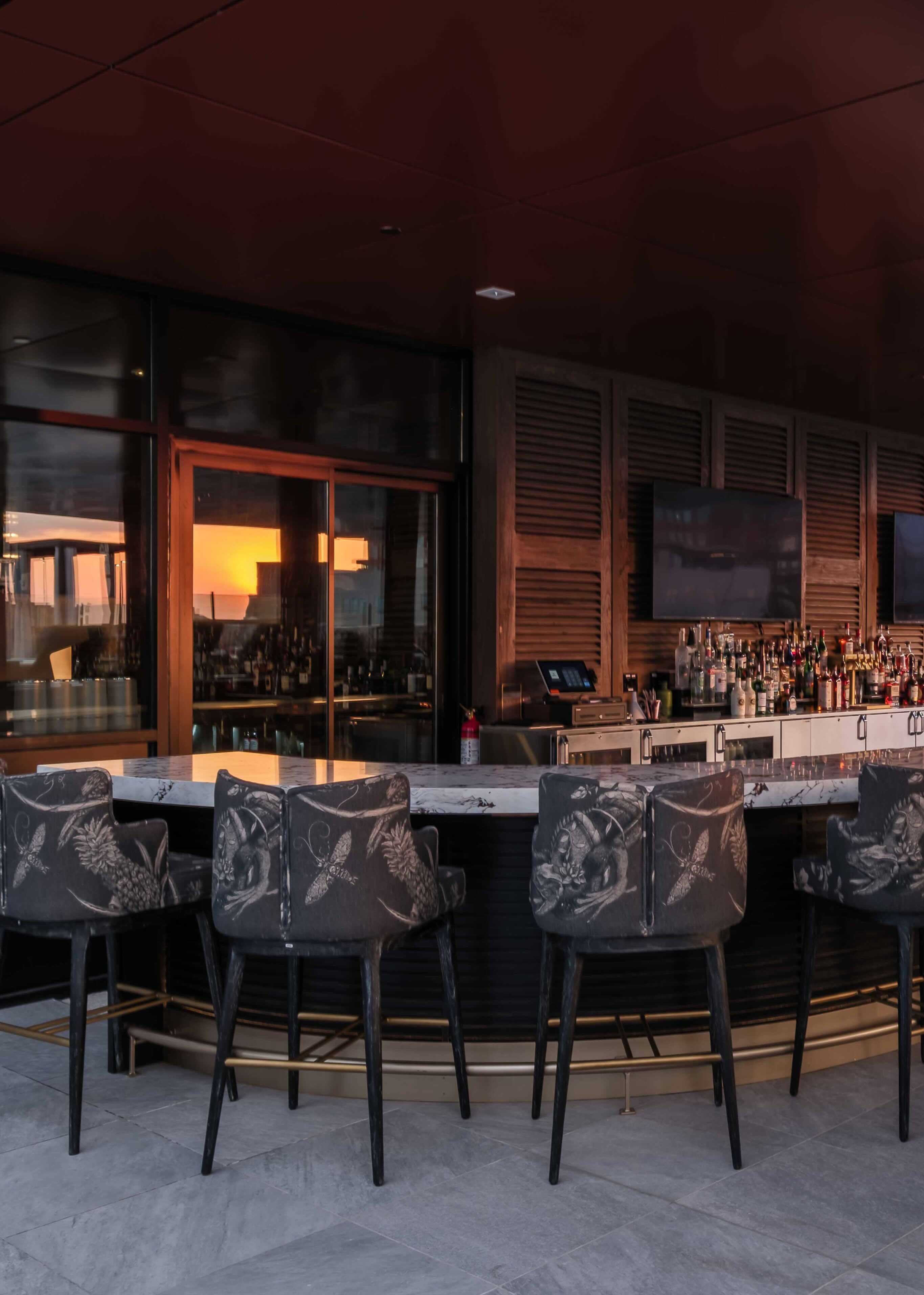 A group of chairs that are sitting in front of a bar.