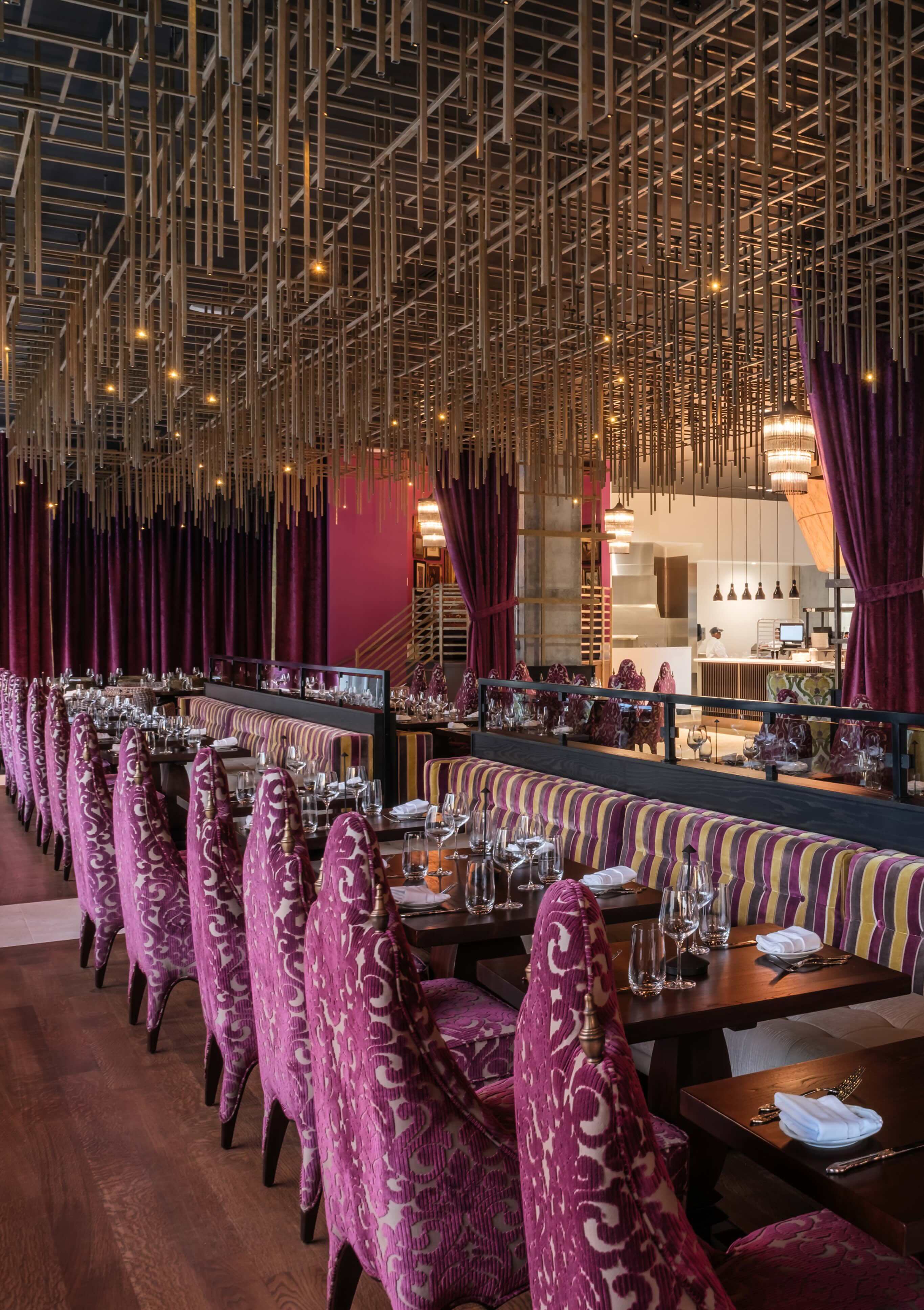 A restaurant with purple chairs and wooden tables.