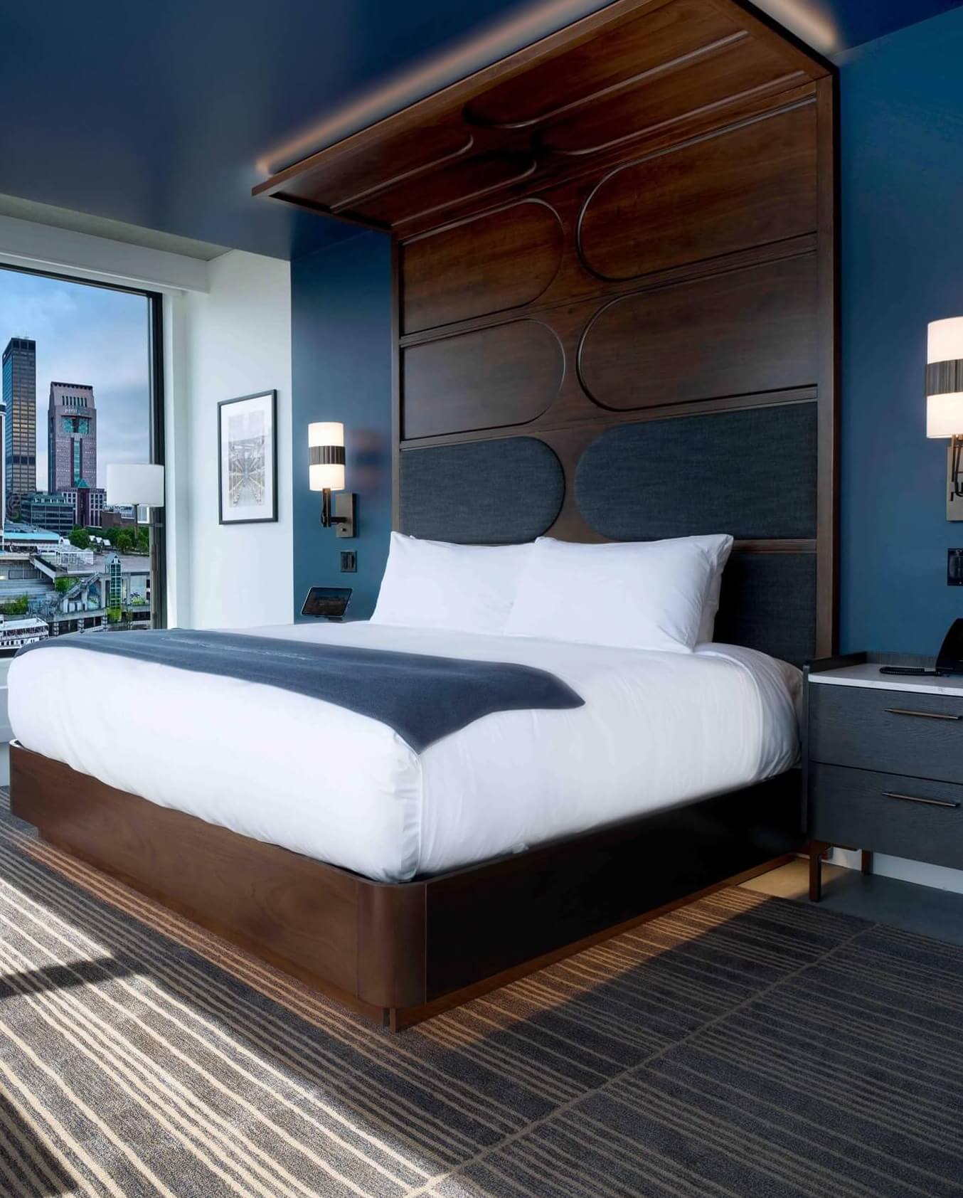 A bedroom with a large bed and a view of the city.