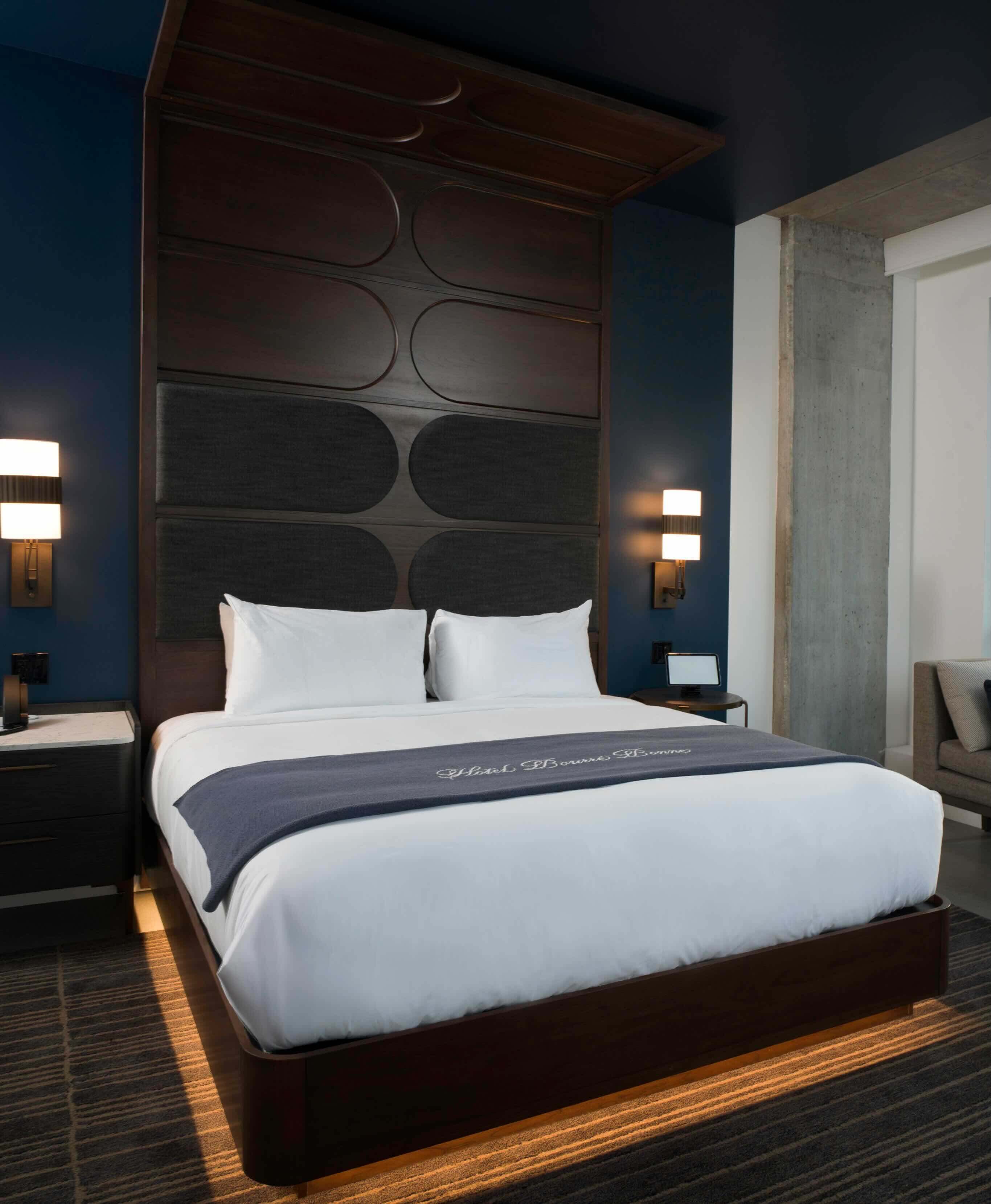 A bedroom with a large bed and a night stand.