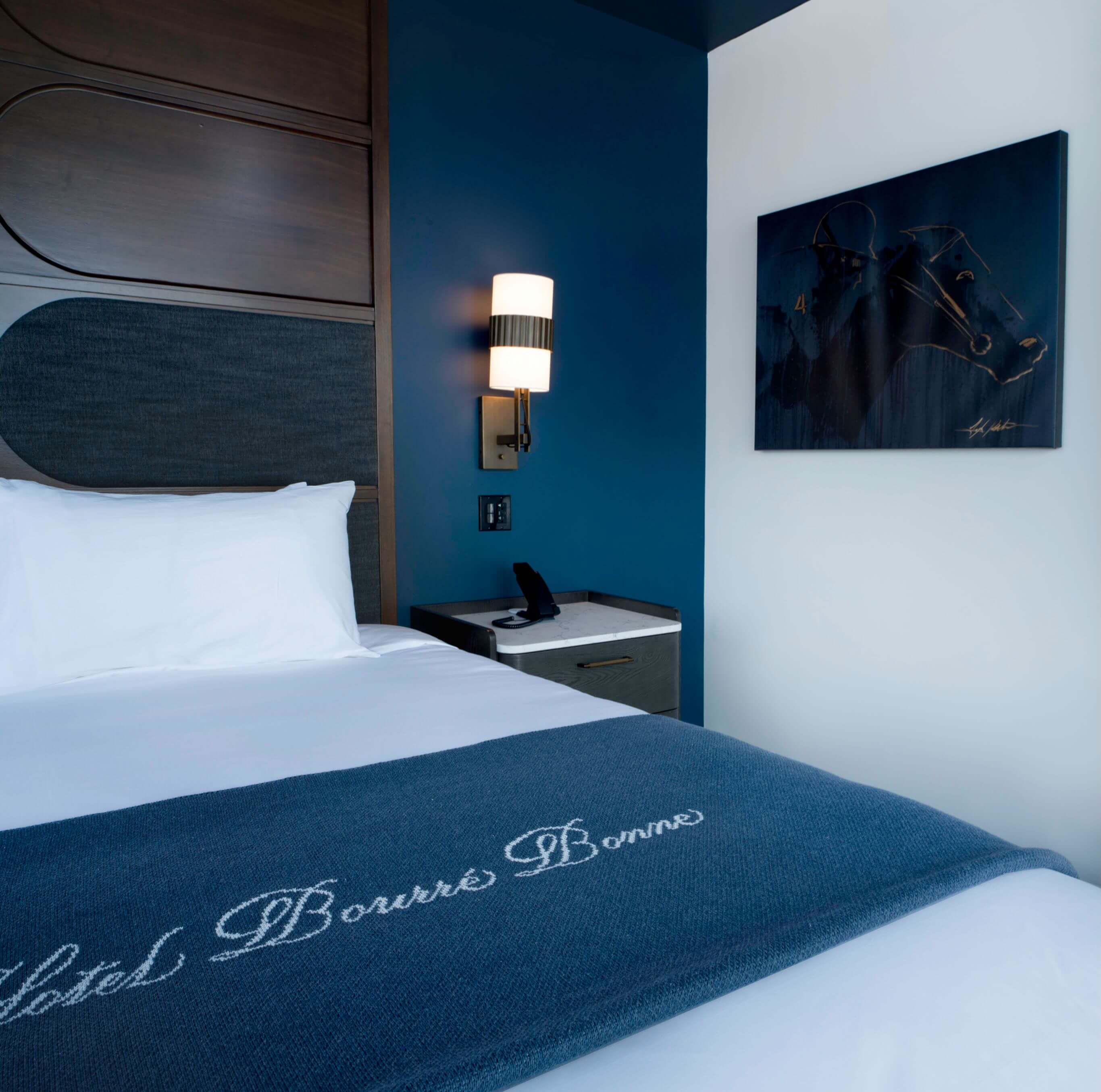A hotel room with a neatly made bed.