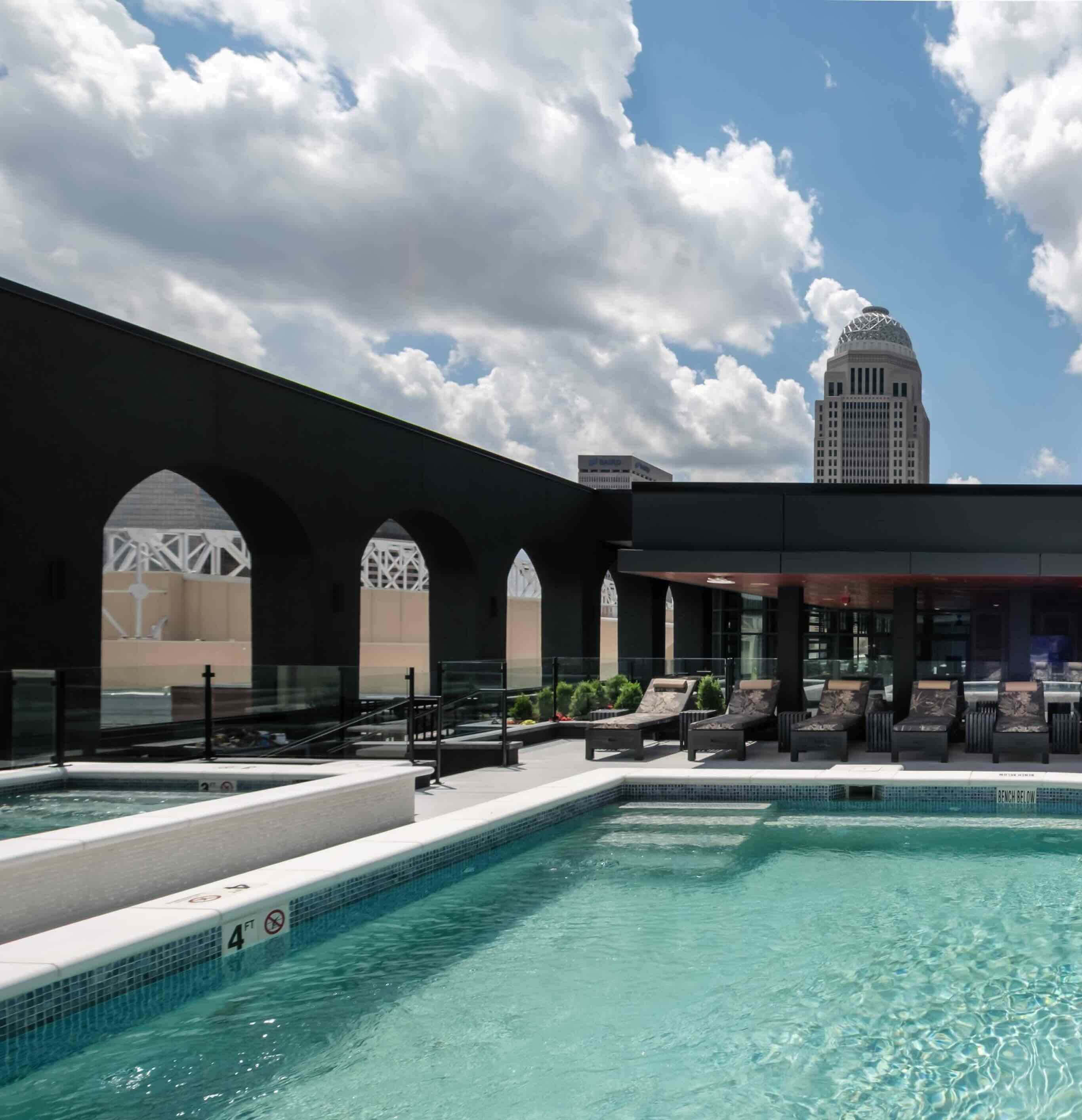 A large swimming pool with lounge chairs around it.