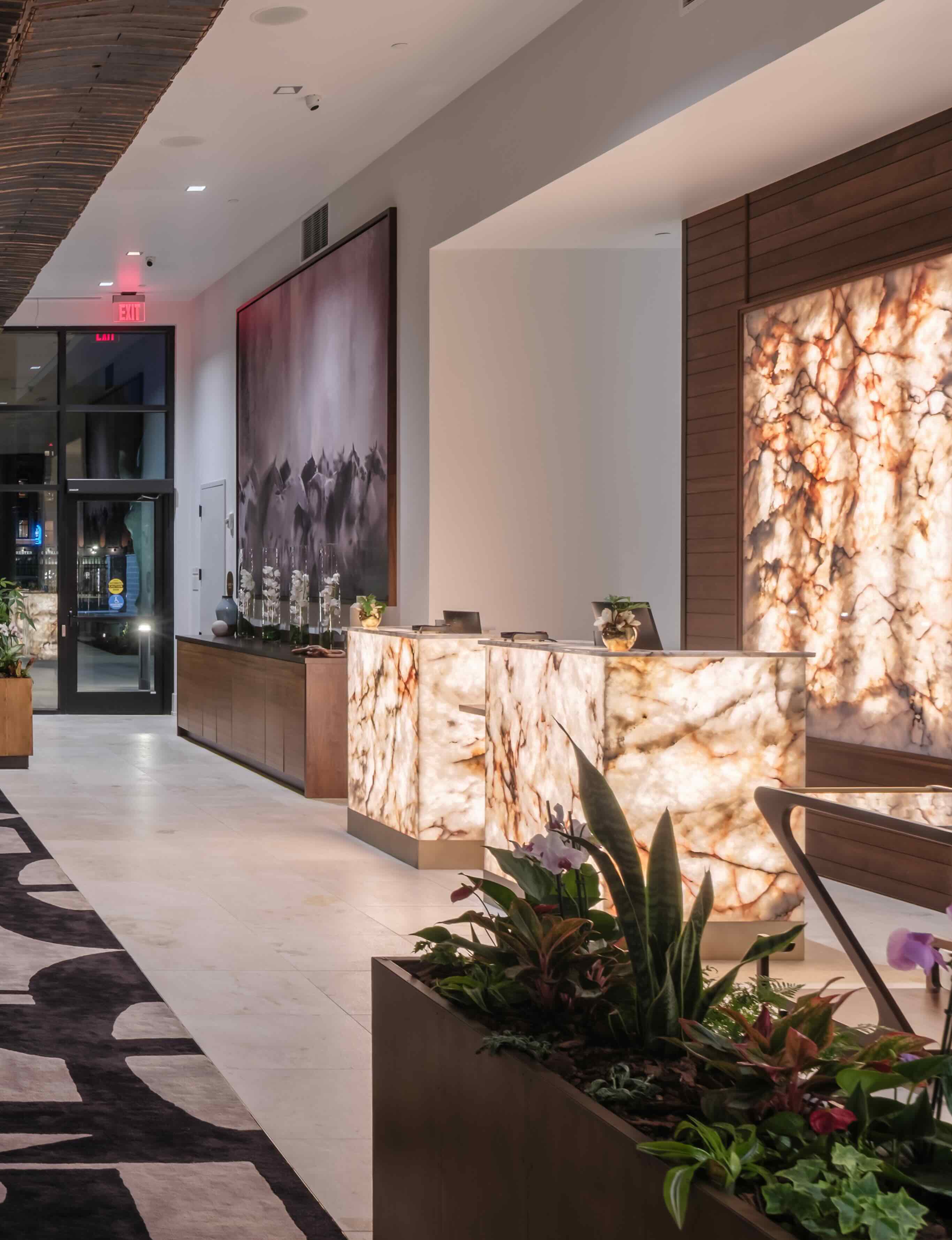 The lobby of a hotel with a large painting on the wall.