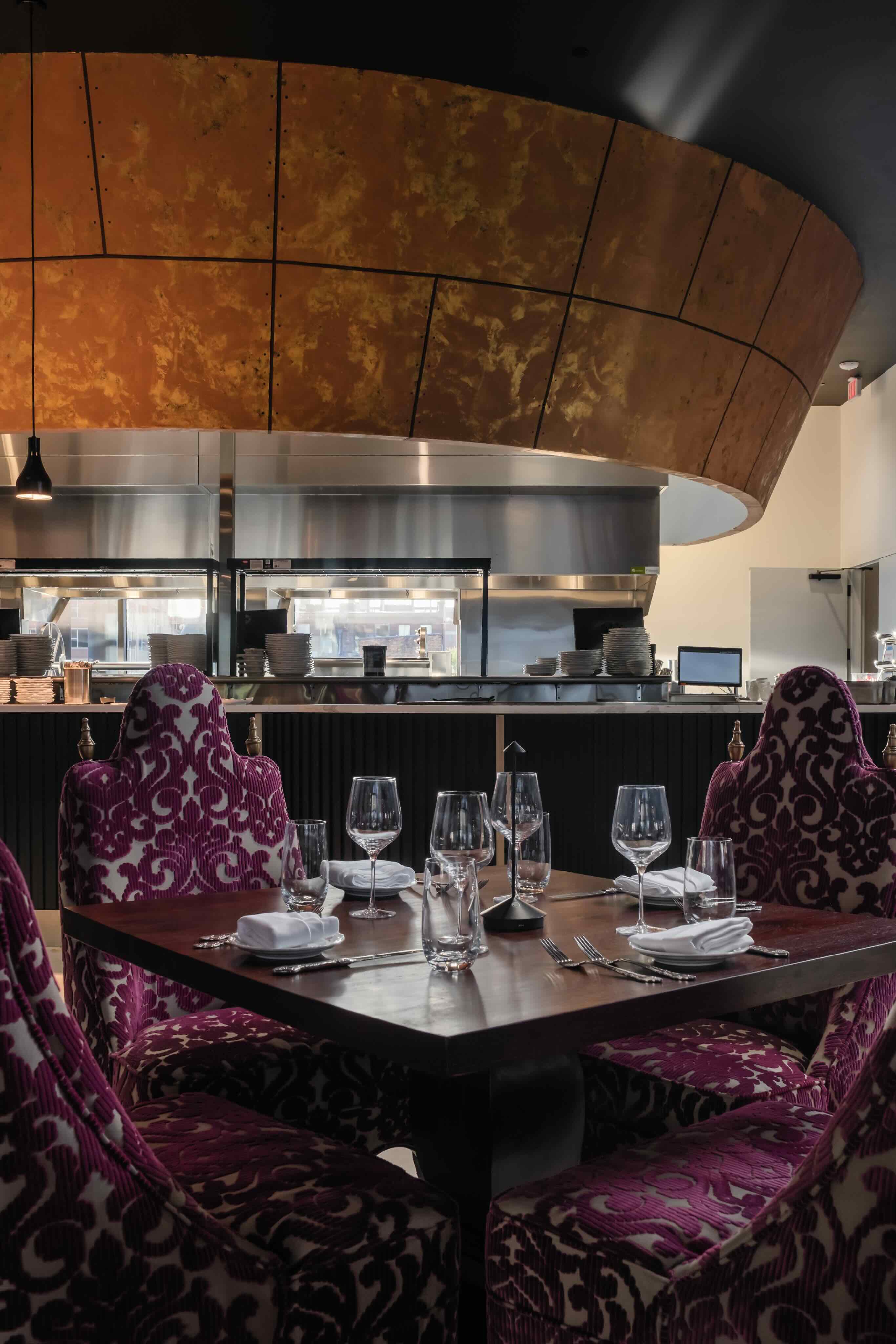 A restaurant with purple chairs and a wooden table.