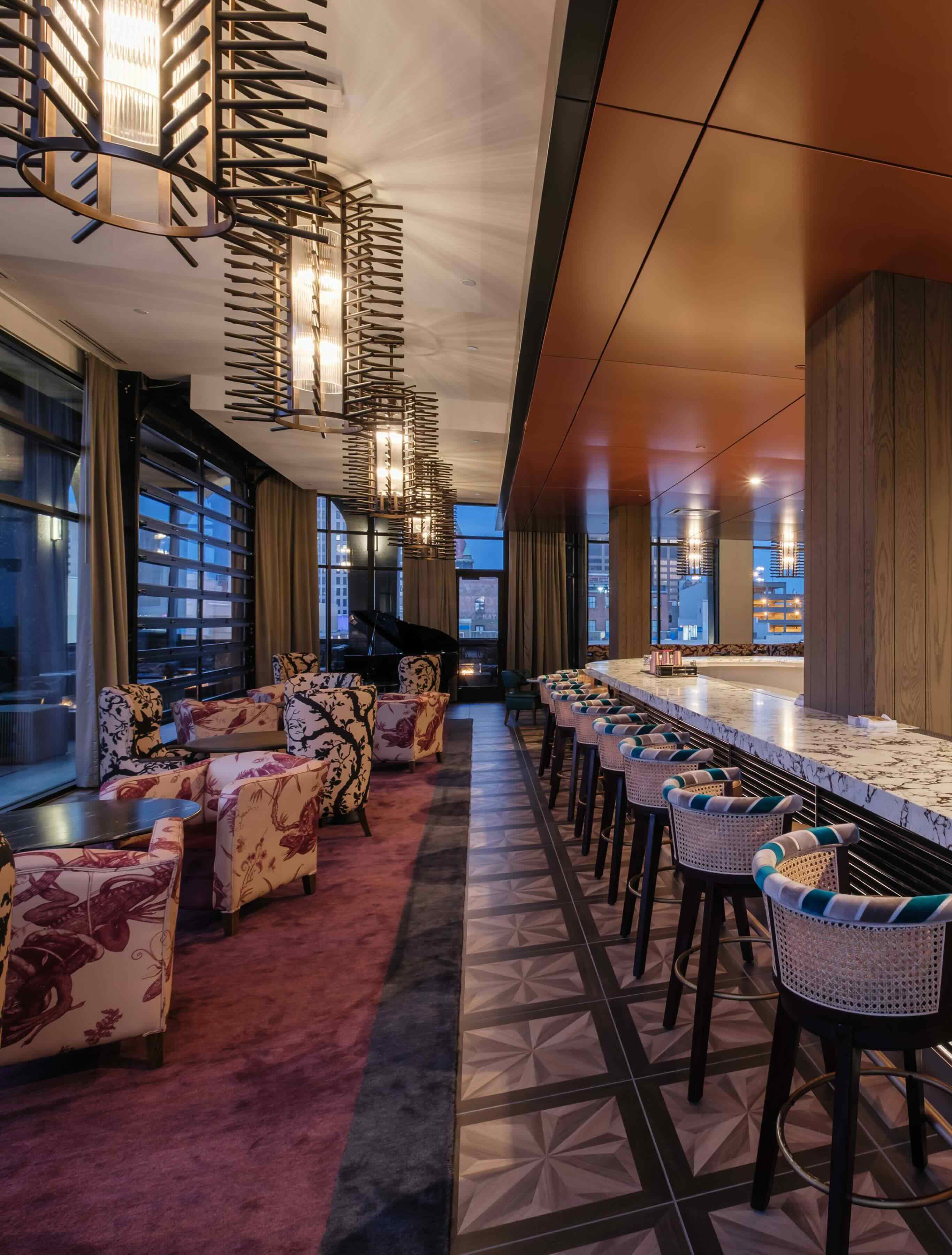 A long bar with a bunch of chairs around it.