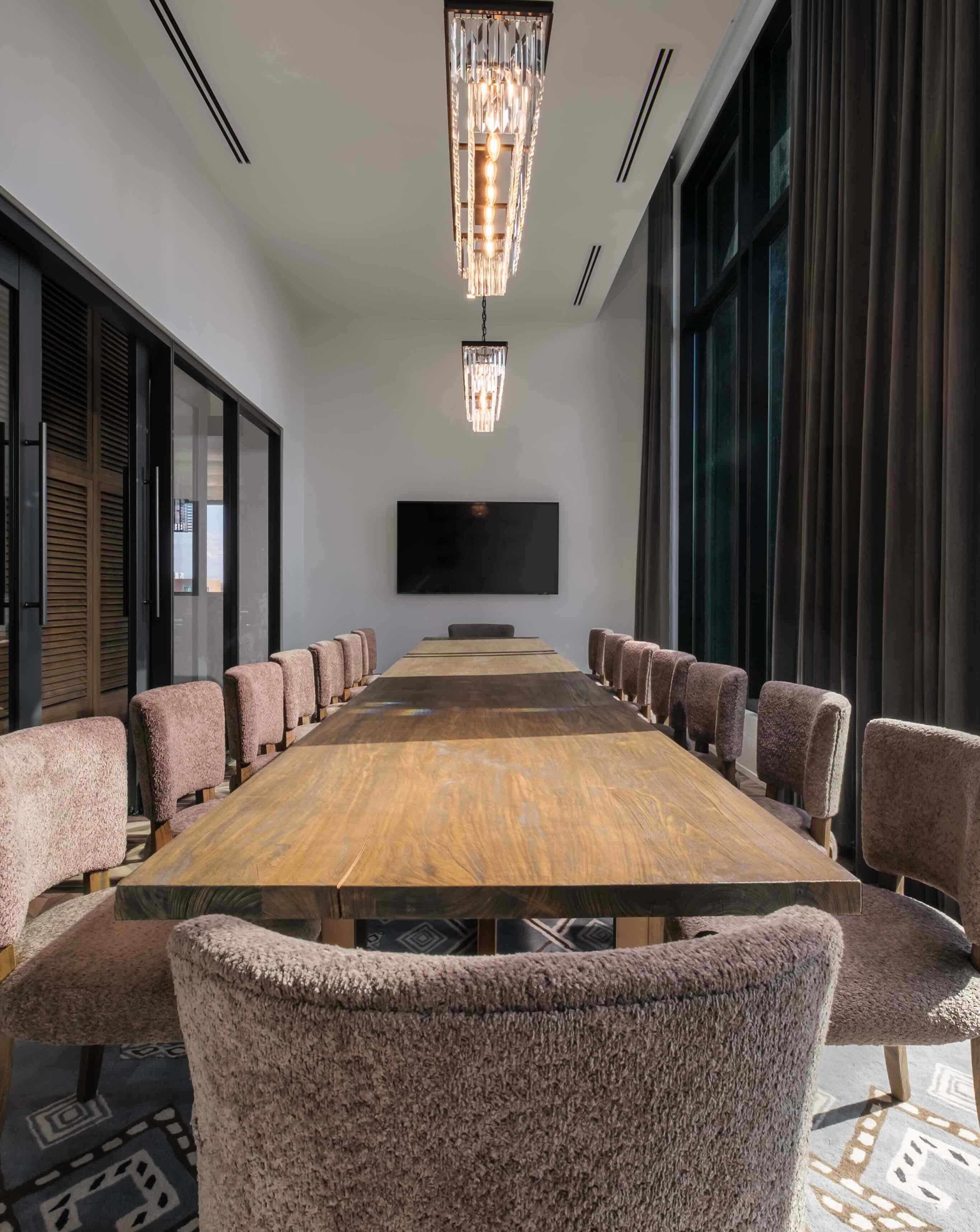 A conference room with a large wooden table and chairs.
