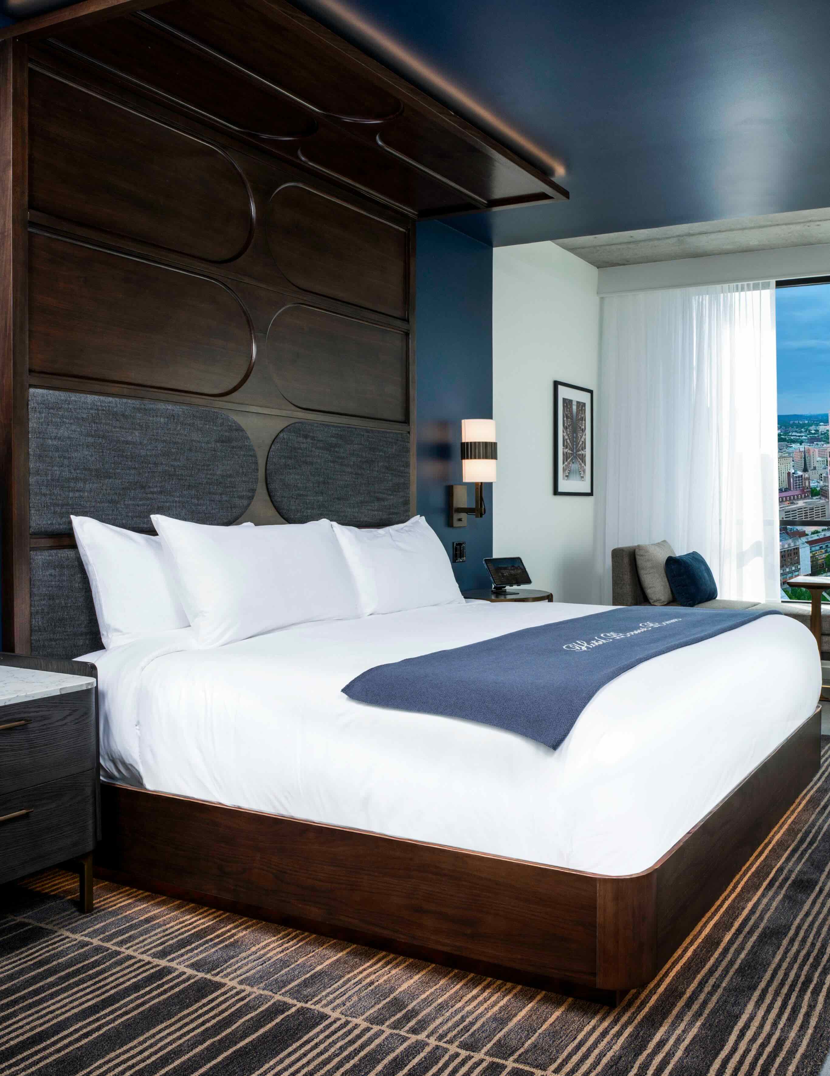 A hotel room with a large bed and a view of the city.