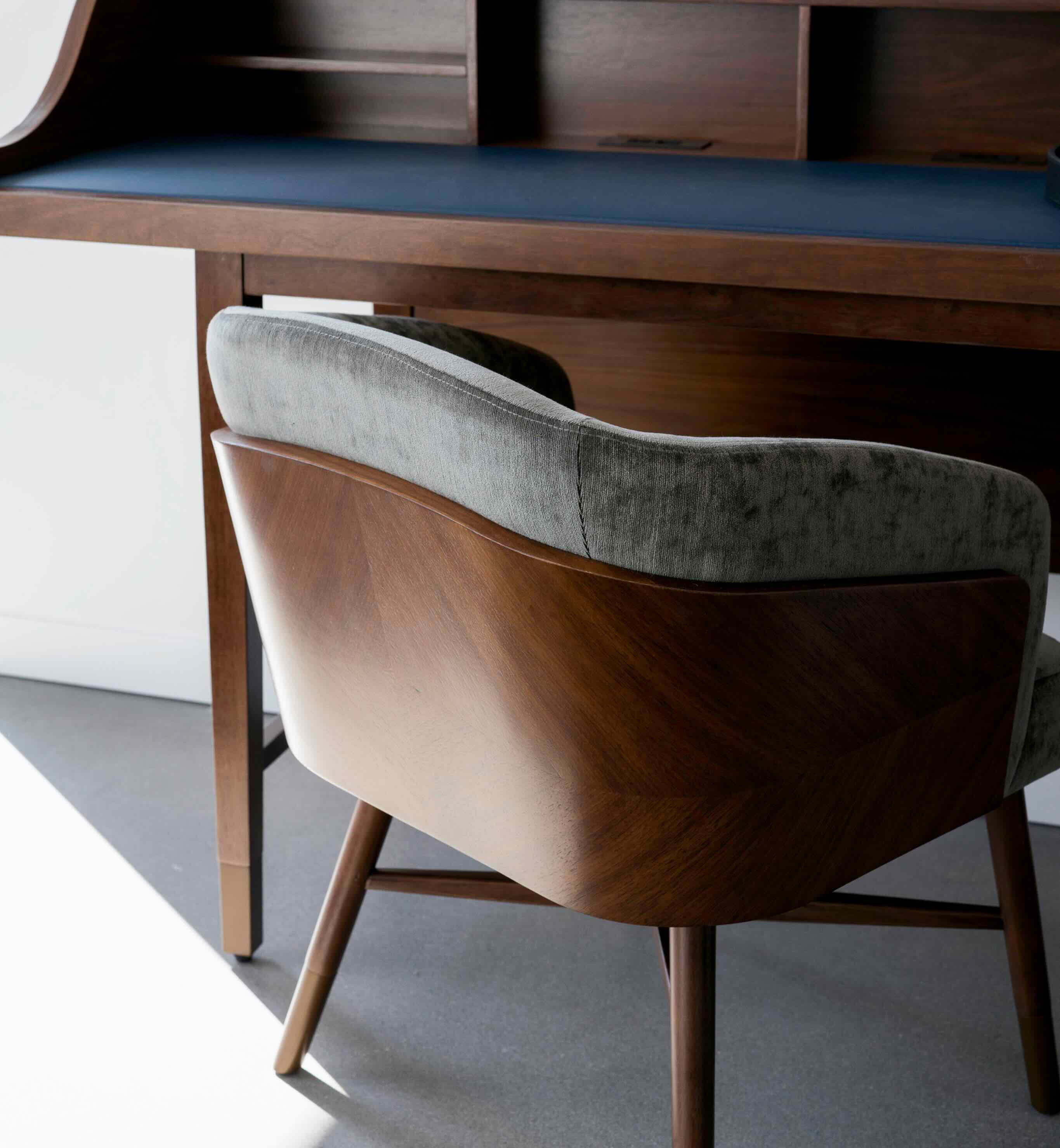A chair sitting in front of a wooden desk.