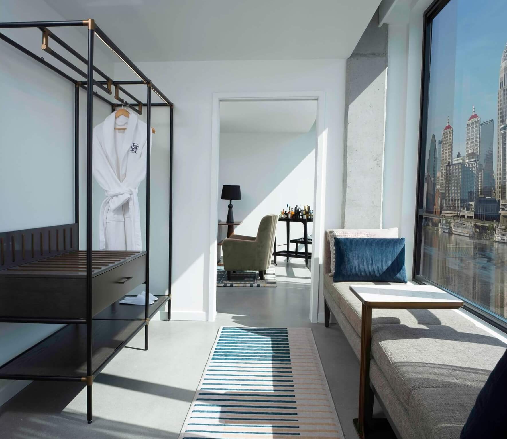 A bedroom with a bed, a couch and a window.