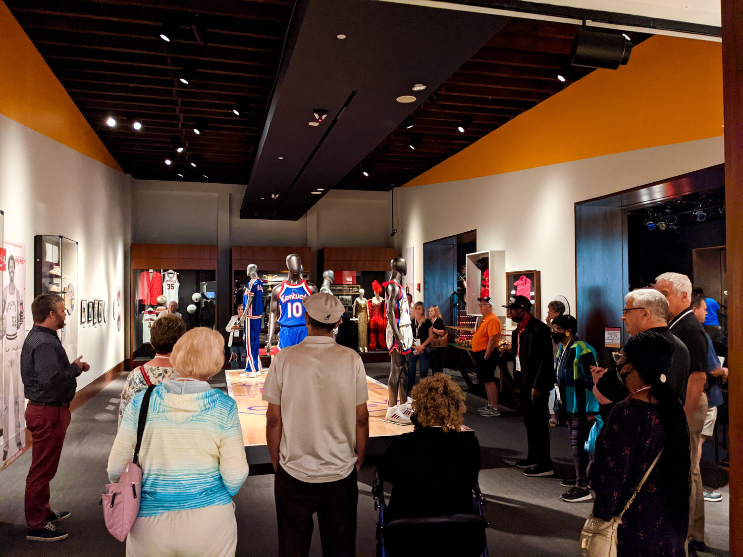 A group of people standing around a museum exhibit.