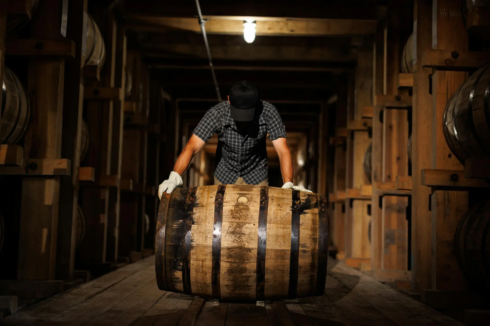 A man in a black and white shirt and some barrels.