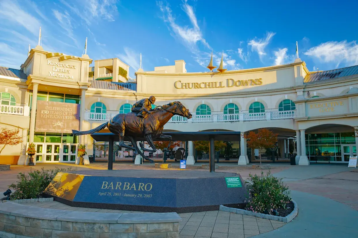 A statue of a man riding a horse in front of a building.
