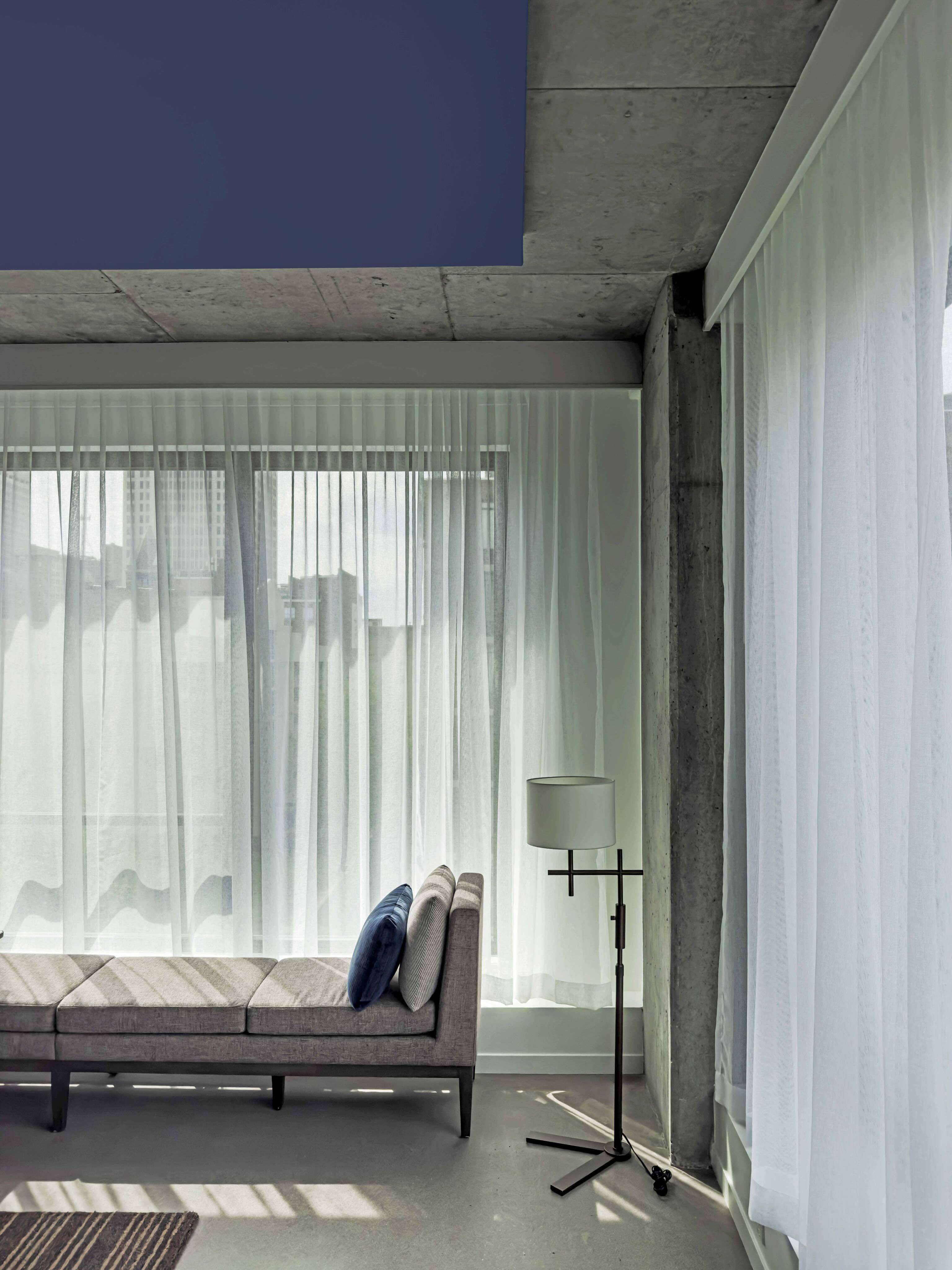 A living room with a couch and a window.