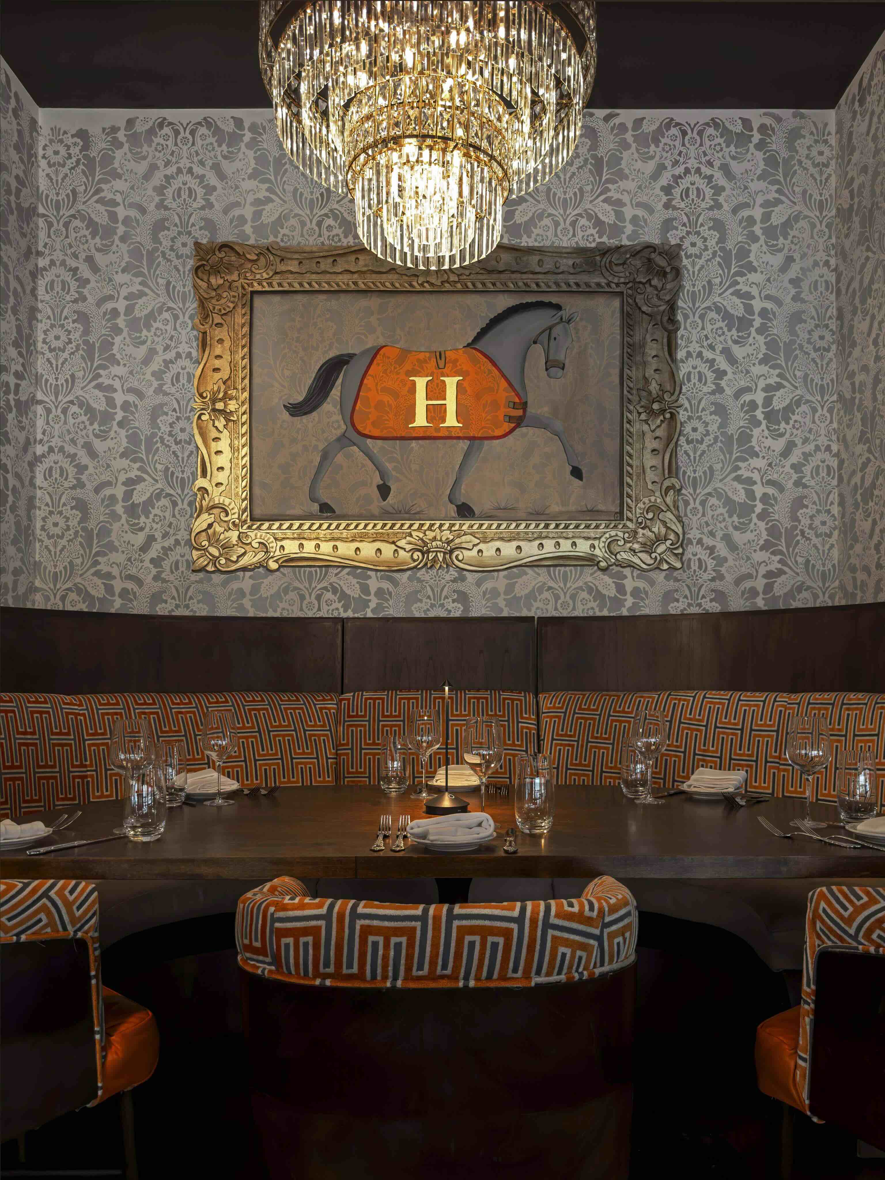 A fancy dining room with a horse painting on the wall.