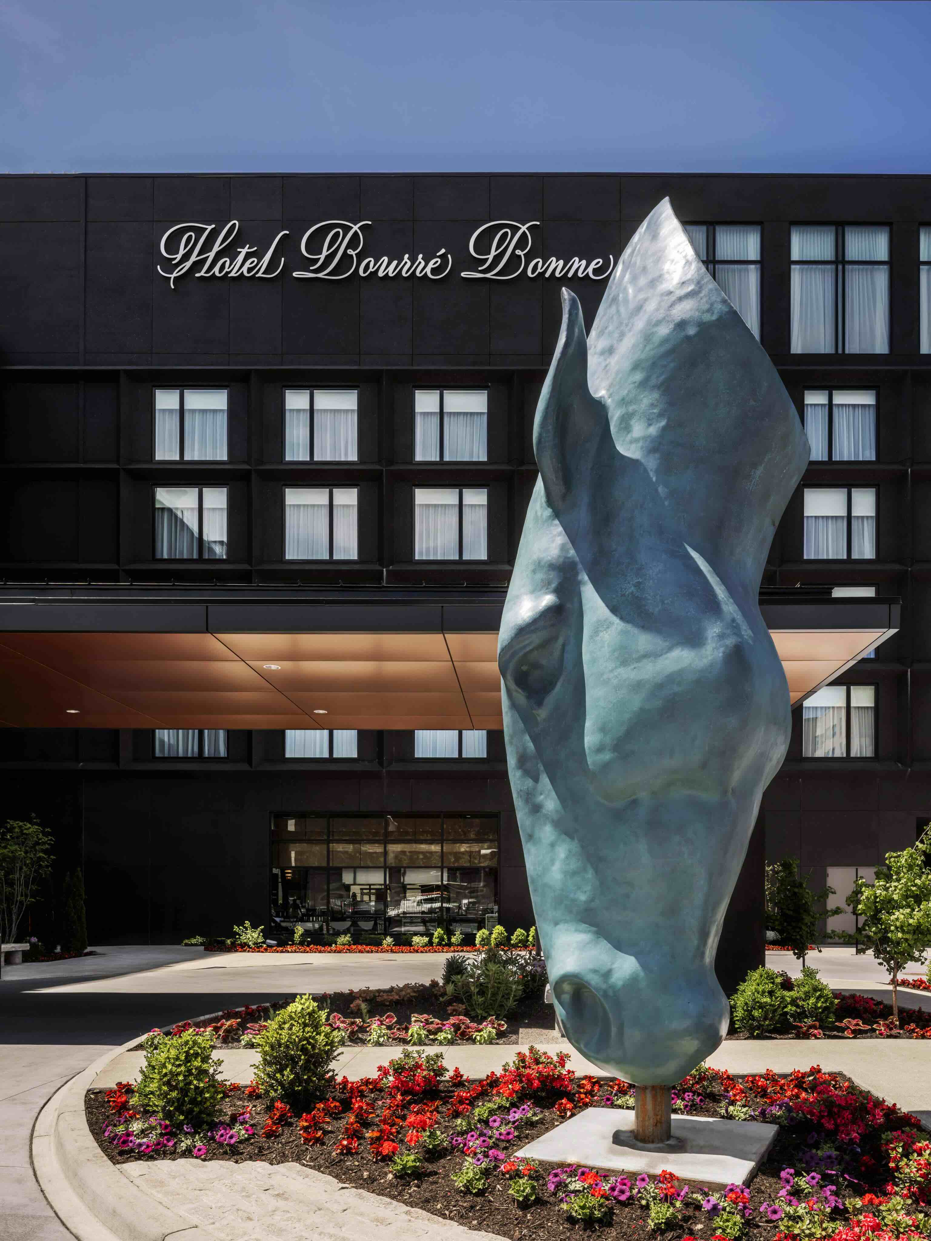 A statue of a horse holding in front of a hotel.