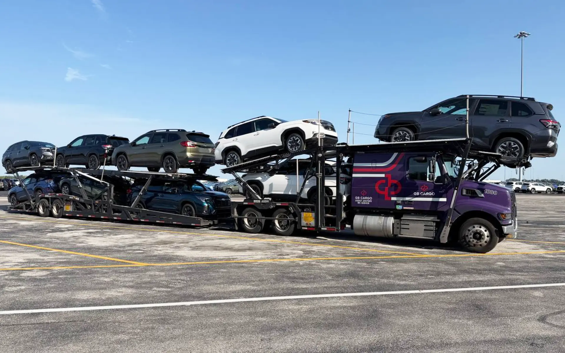 A 9-car-hauling truck loaded with cars parked at in a parking lot.