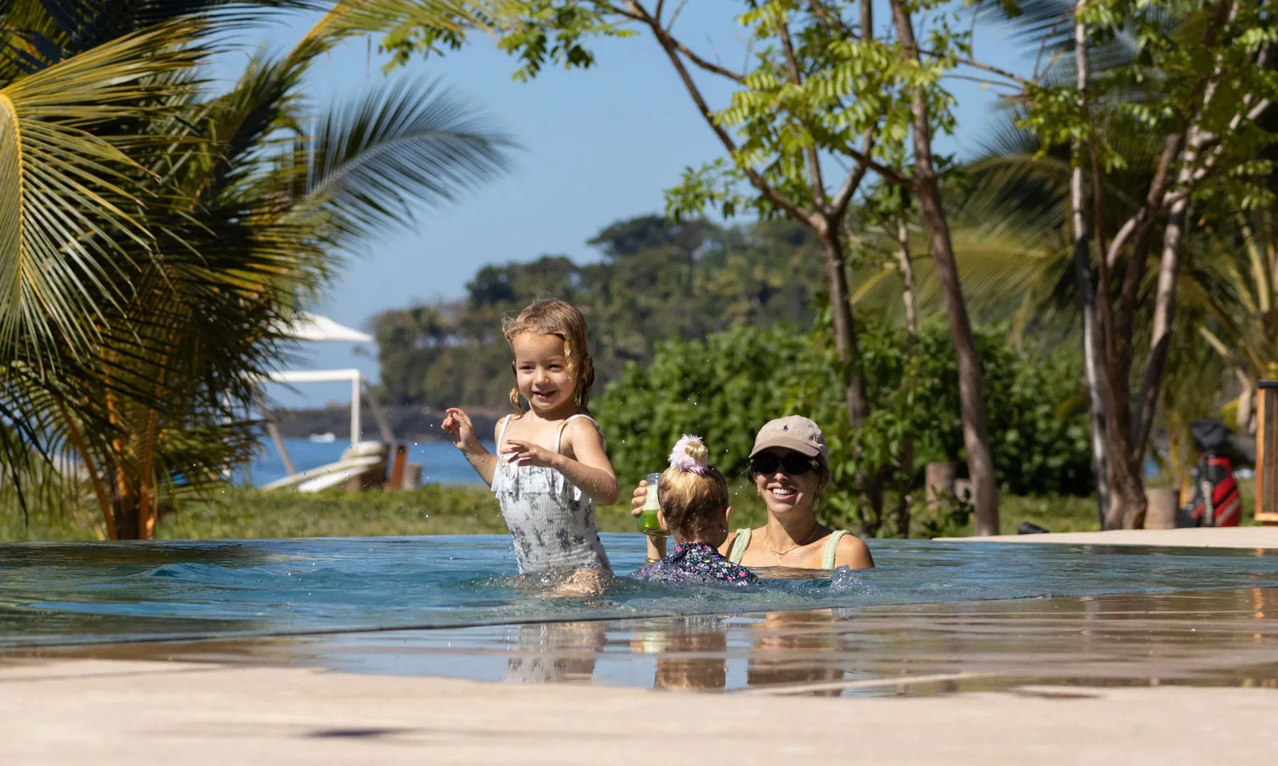 Woman and young child playing in pool at Nauka Village