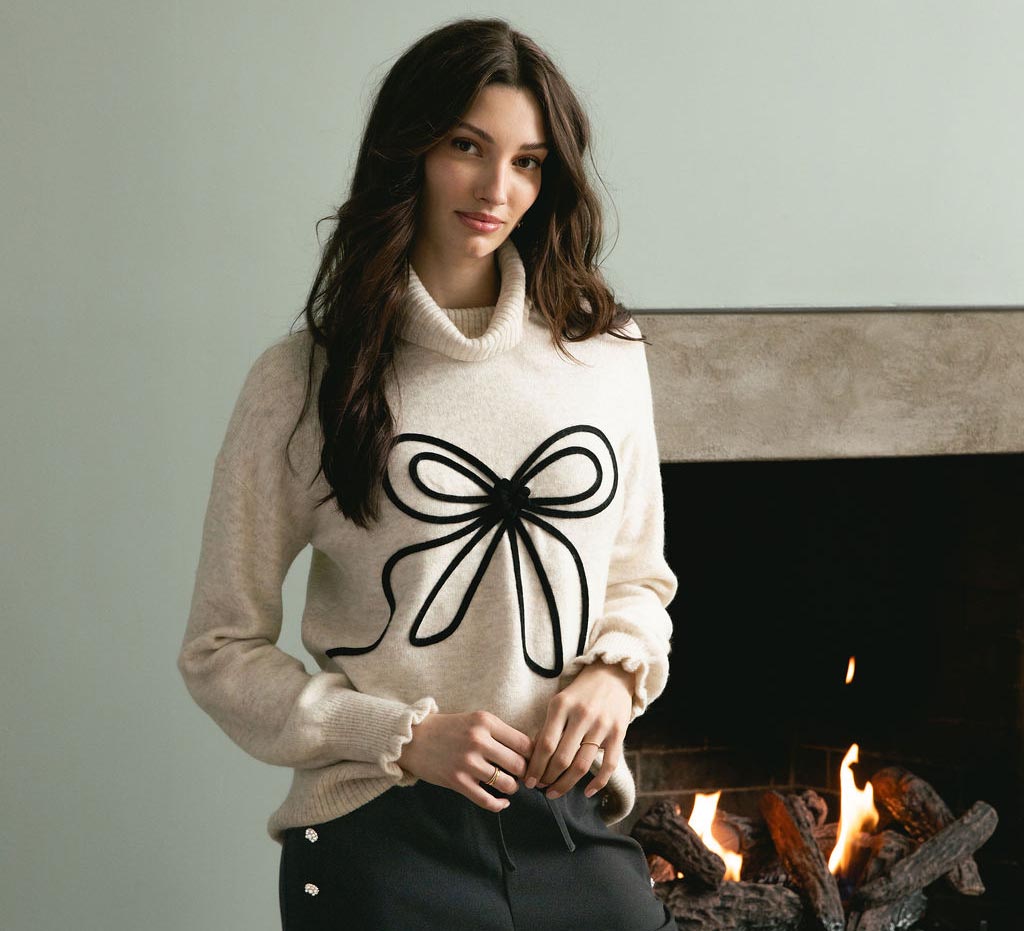 A woman wearing a black and white shirt with a bow around her neck.