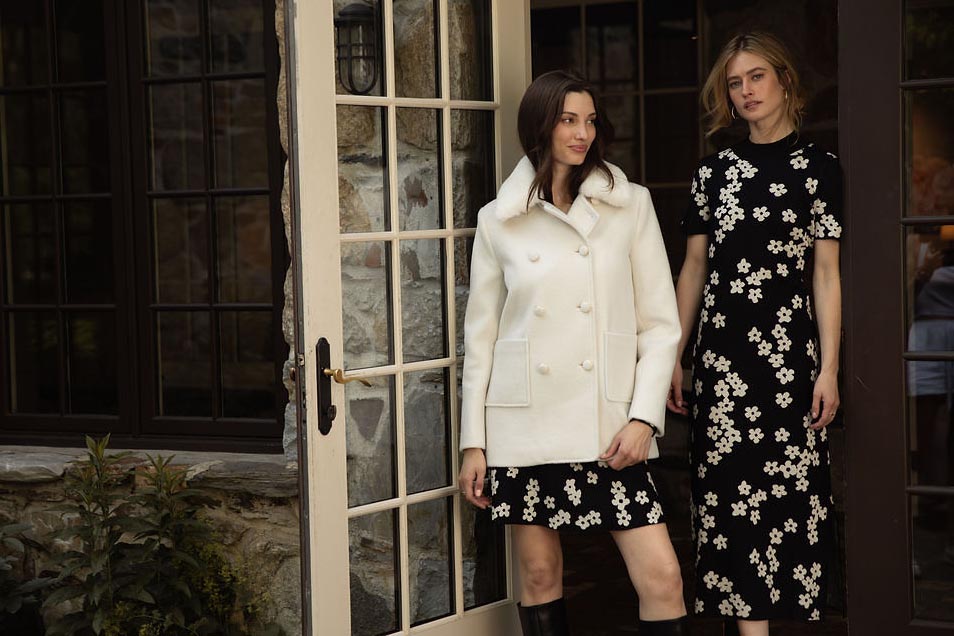 A woman standing in front of a fireplace in a room.