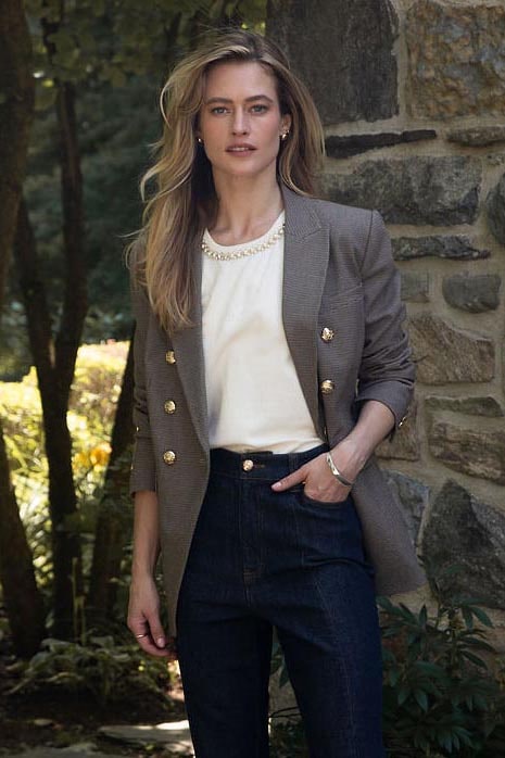 A woman wearing a black dress and a brown bow tie.