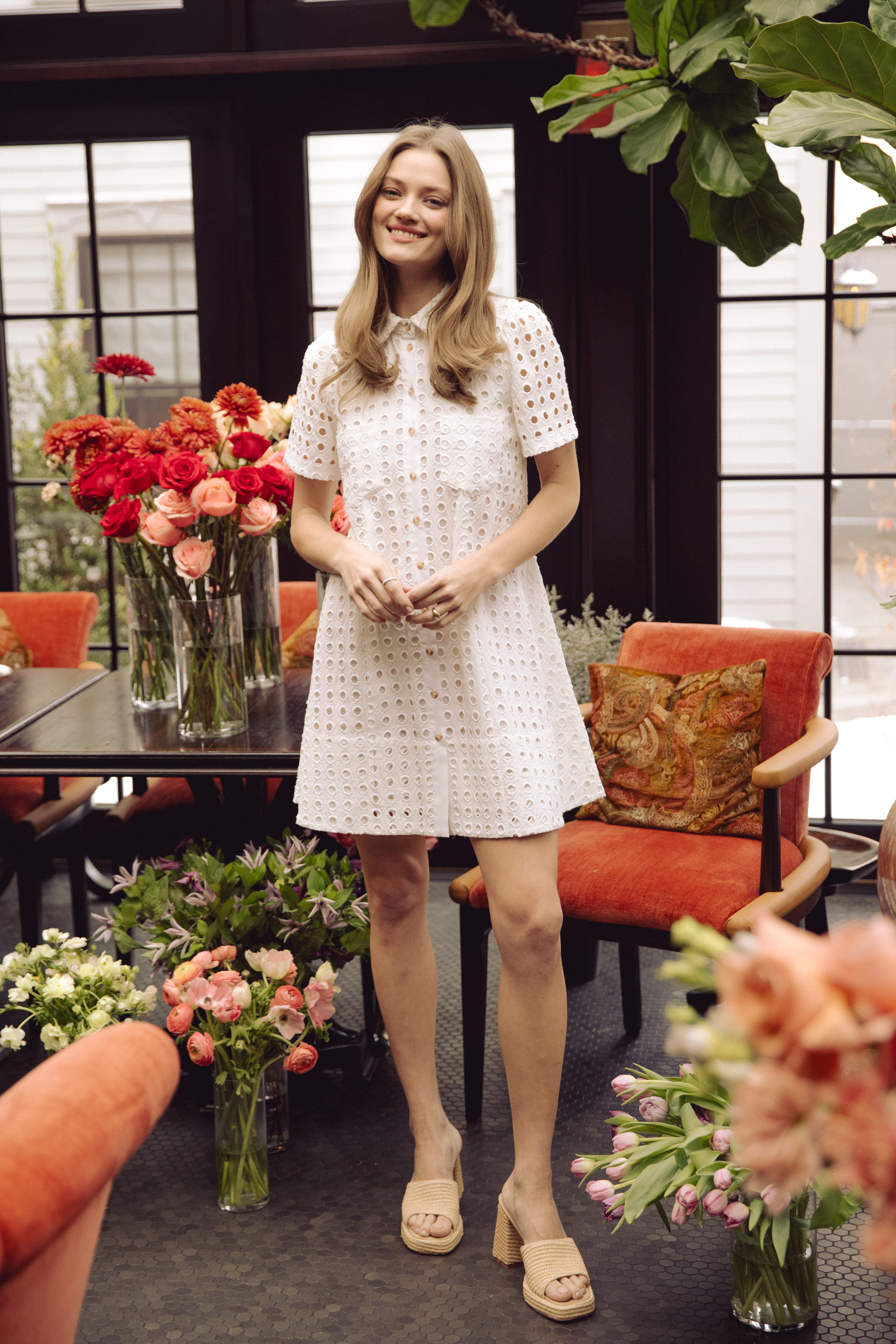 A woman in a gray sweater with a black bow.