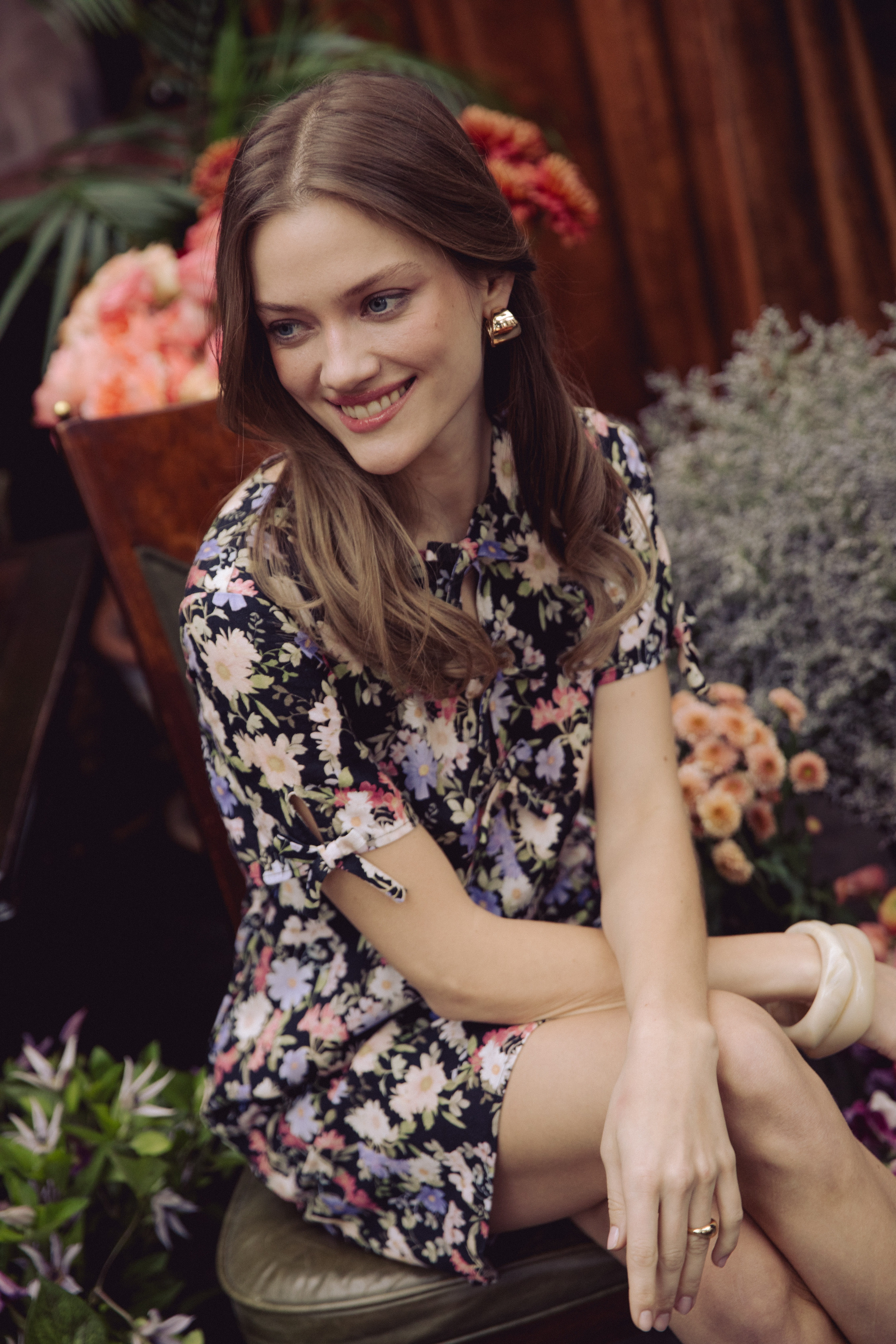 A woman standing in a room wearing a skirt and boots.