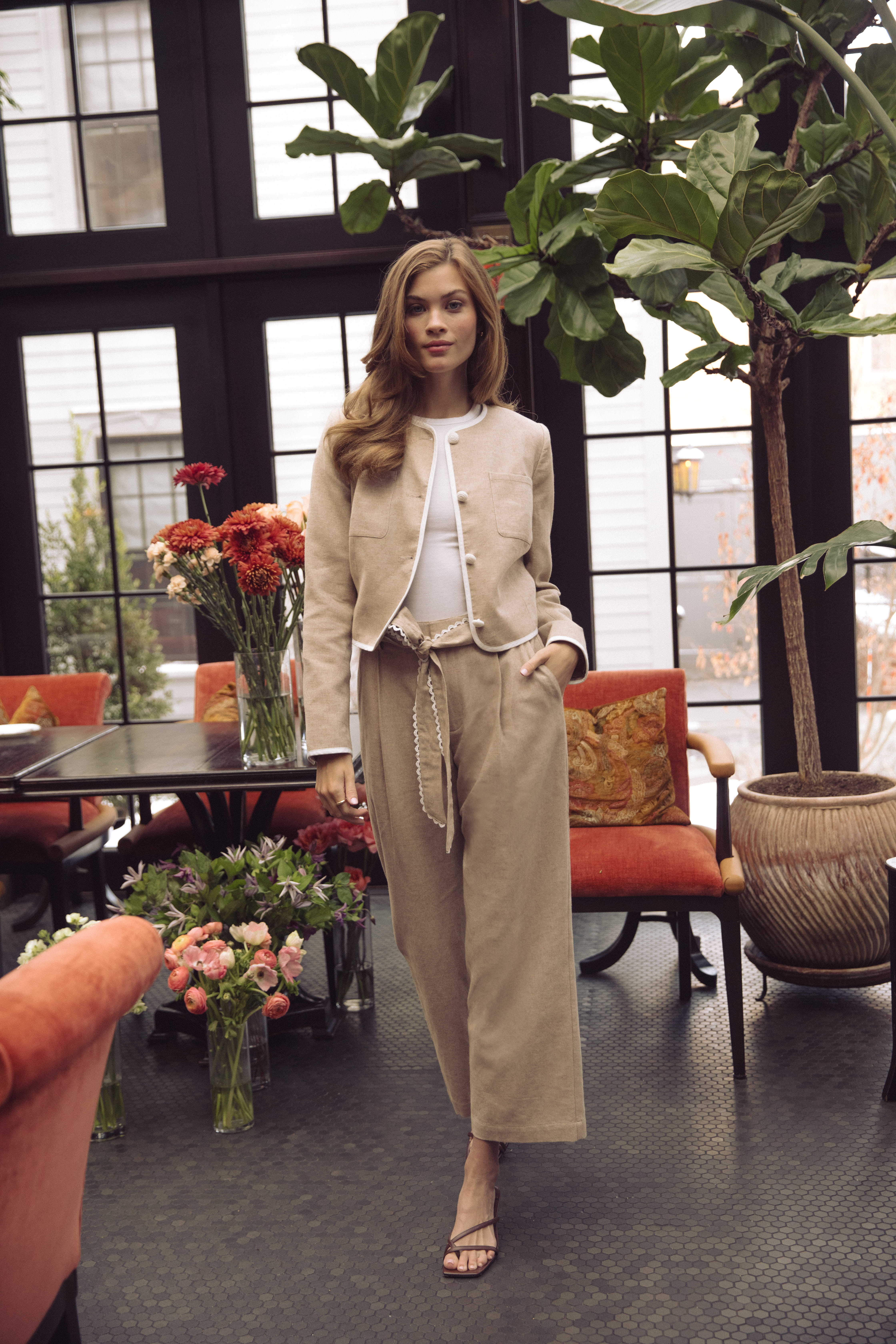 A woman wearing a white shirt and a flower necklace.