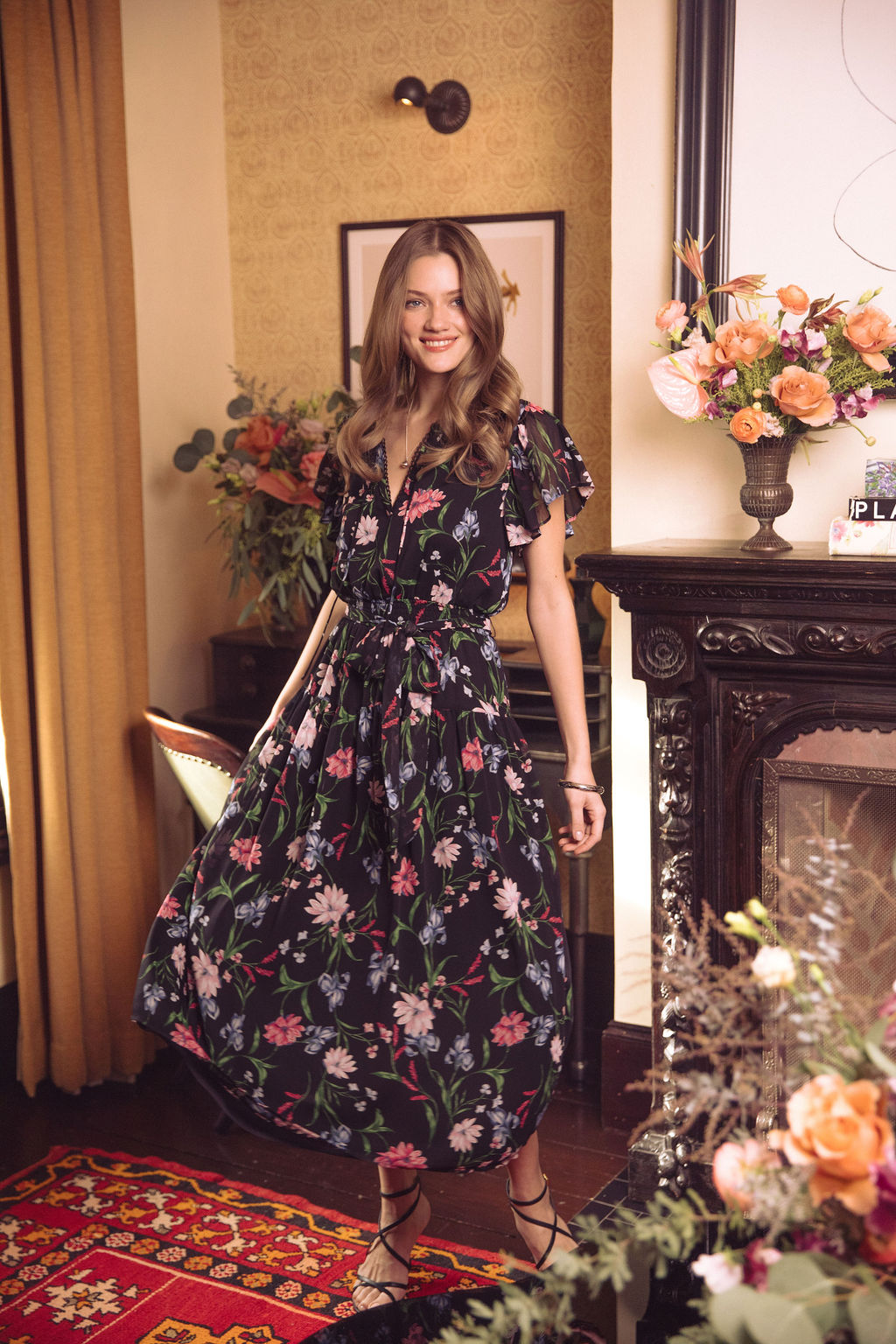 A woman standing next to a lamp post.